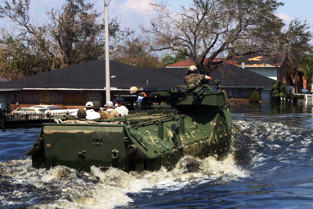 Marines in amphibious vehicles and infantrymen travel down the decimated streets of Orleans Parish conducting search-and-rescue operations in New Orleans, Sept. 8, 2005. Some communities in the parish were under more than 10 feet of water. The Marines are assigned to the Special Purpose Marine Air Ground Task Force Katrina. U.S. Marine Corps photo by Cpl. Rocco DeFilippis
