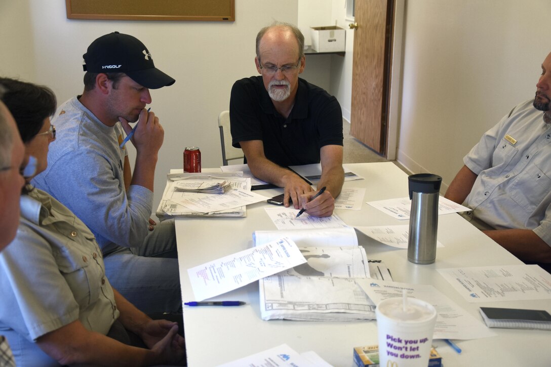 Resident engineer Scott Baker, center, talks with the contractor and project partners Aug. 11, 2015, during the weekly progress meeting for the Harper’s Slough project. The Harper’s Slough Habitat Rehabilitation and Enhancement Project, located within the Upper Mississippi River National Wildlife and Fish Refuge, was planned and designed under the authority of the Upper Mississippi River Restoration Program. It will protect five existing islands and construct an additional seven islands using material from the backwater and main channel. The program emphasizes habitat rehabilitation and enhancement projects and long-term resource monitoring. Project component includes dredging backwater areas and channels, constructing dikes, creating and stabilizing islands and controlling side channel flows and water levels. Once the project is completed, the project will be turned over to the U.S. Fish and Wildlife Service, who manages the refuge.