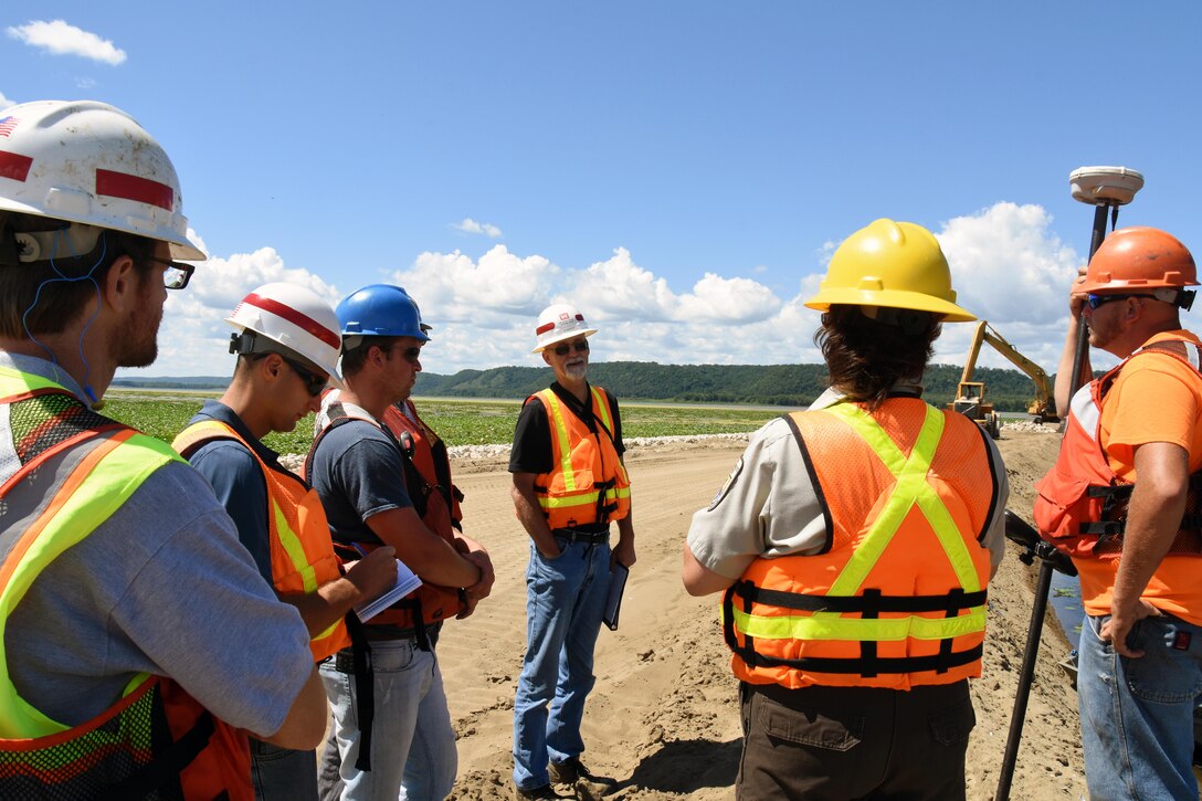 Resident engineer Scott Baker, center, talks with the contractor and project partners Aug. 11, 2015, during the weekly progress meeting for the Harper’s Slough project. The Harper’s Slough Habitat Rehabilitation and Enhancement Project, located within the Upper Mississippi River National Wildlife and Fish Refuge, was planned and designed under the authority of the Upper Mississippi River Restoration Program. It will protect five existing islands and construct an additional seven islands using material from the backwater and main channel. The program emphasizes habitat rehabilitation and enhancement projects and long-term resource monitoring. Project component includes dredging backwater areas and channels, constructing dikes, creating and stabilizing islands and controlling side channel flows and water levels. Once the project is completed, the project will be turned over to the U.S. Fish and Wildlife Service, who manages the refuge.