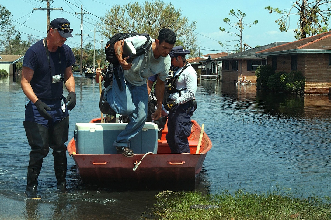 Members of the Coast Guard, Sector Ohio Valley Disaster Area Responce Team and the Miami-Dade Urban Search and Rescue Team help rescue a Hurricane Katrina victim in New Orleans, Sept. 6, 2005. The Coast Guard is working hand-in-hand with many organazations from around the country to assist the hurricane victims. U.S. Coast Guard photo by Petty Officer Robert Reed