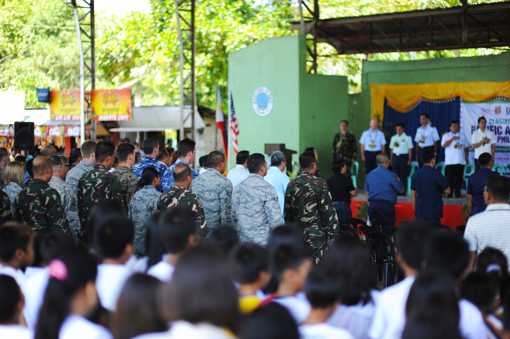 Attendees of the closing ceremony of Pacific Angel Philippines 15-1 stand during the playing of the Bohol hymn at Dao Elementary School, Bohol province, Philippines, Aug. 24, 2015. Over the course of six days, 5,101 patients received health care and six different schools were refurbished providing rehabilitated learning space to approximately 5,000 students. Efforts undertaken during Pacific Angel help multilateral militaries in the Pacific improve and build relationships across a wide spectrum of civic operations, which bolsters each nation’s capacity to respond and support future humanitarian assistance and disaster relief operations. (U.S. Air Force photo by Tech. Sgt. Aaron Oelrich/Released)
