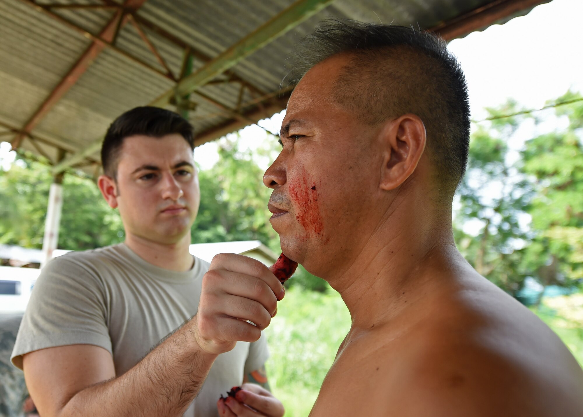 Senior Airmen Johon Scacca, a mass casualty instructor from Yokota Air Force Base, Japan, prepares a moulage patient during the Pacific Angel Philippines mass-casualty exercise, Bohol Province, Philippines, Aug. 21, 2015. The mass casualty exercise was the culminating event of a five-day subject matter expert exchange between the U.S. Defense Institute for Medical Operations, the Armed Forces of the Philippines, the Philippine National Police, the Telephone and Radio System Integrated Emergency Response, the Provincial Heath Care Unit and the City Heath Care Unit. Pacific Angel is a multilateral humanitarian assistance civil military operation, which improves military-to-military partnerships in the Pacific while also providing medical health outreach, civic engineering projects and subject matter exchanges among partner forces. (U.S. Air Force photo by Tech. Sgt. Aaron Oelrich/Released)