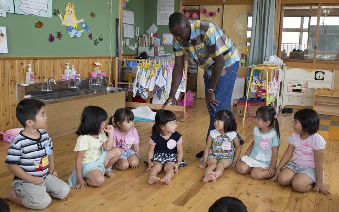 Lance Cpl. Derek Asiamah, a postal clerk with Headquarters and Headquarters Squadron based aboard Marine Corps Air Station Iwakuni, Japan, plays duck, duck, goose with students at Josho Hoikuen School in Iwakuni City as part of a community relations event hosted by the Marine Memorial Chapel, Aug. 11, 2015. Marine Memorial Chapel hosts community relations events that give volunteers the chance to be a positive role model for their Japanese neighbors and become a part of the community.