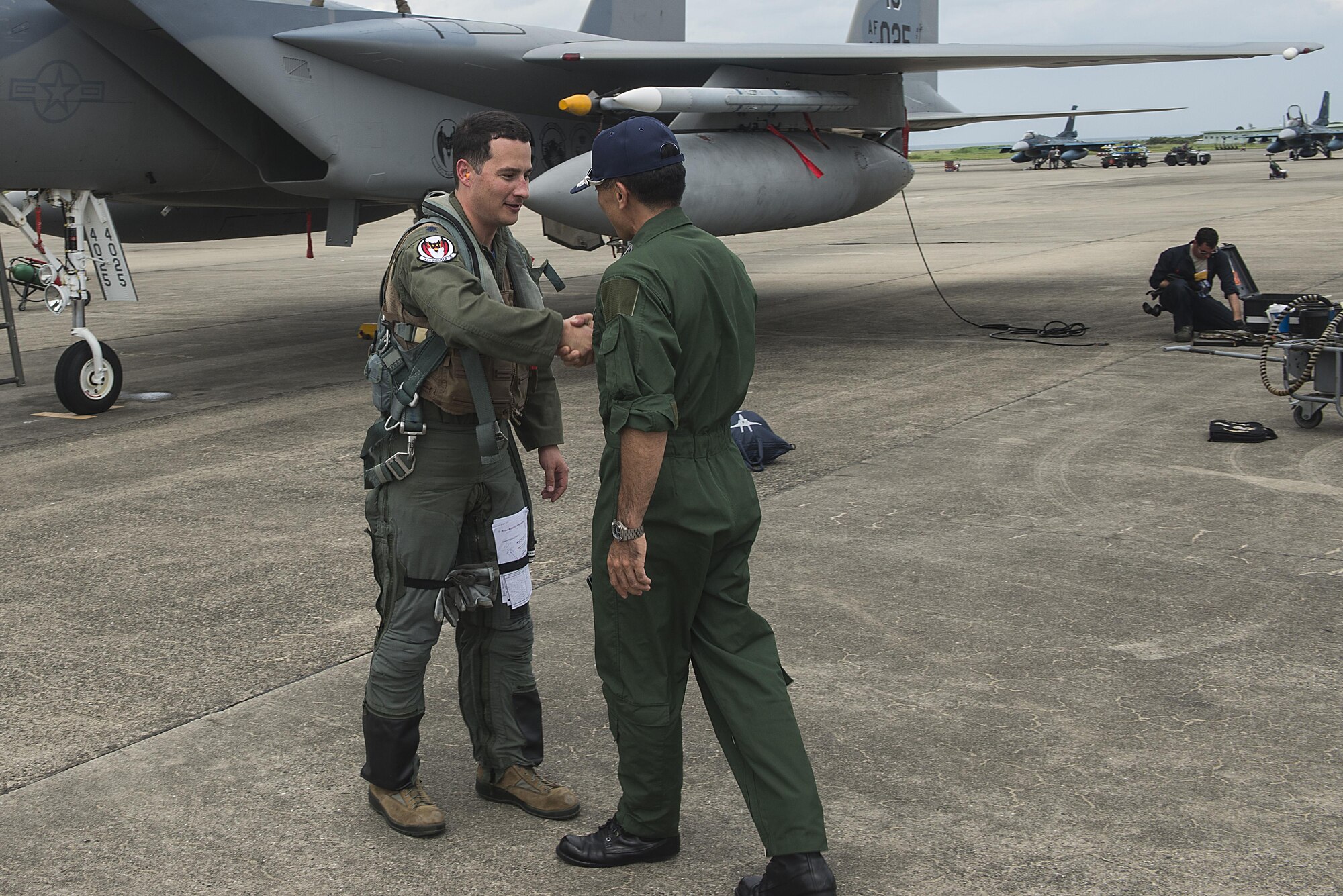 Japanese Air Self-Defense Force Col. Hirohisa Takakusaki, 8th Air Wing Operations Group commander, greets U.S. Air Force Lt. Col. Kevin Jamieson, 44th Fighter Squadron commander, at Tsuiki Air Base, Japan, Aug. 21, 2015. More than 150 Airmen from the 18th Wing and the first group of F-15 Eagles from the 44th Fighter Squadron began Aviation Training Relocation today at Tsuiki Air Base, Japan. (U.S. Air Force photo by Senior Airman Stephen G. Eigel)