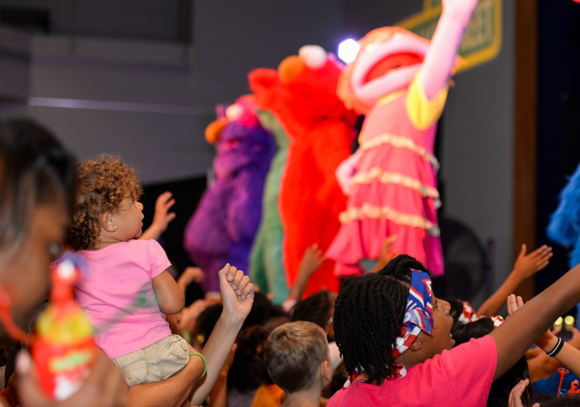 Children reach toward the stage at the end of the United Service Organization Sesame Street presentation at Yokota Air Base, Japan, Aug. 21, 2015. Children had the opportunity to see and learn from Katie the Muppet, who experiences struggles common to military children. (U.S. Air Force photo by Airman 1st Class Elizabeth Baker/Released)
