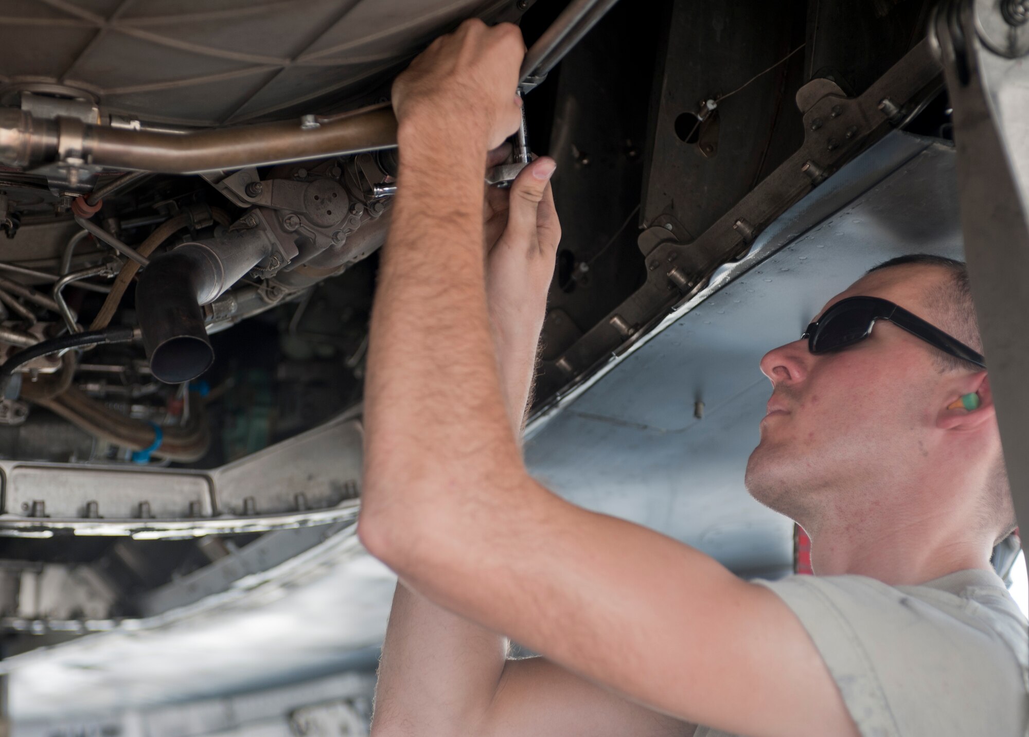 Senior Airman Shawn Lawson, 757th Aircraft Maintenance Squadron Strike Aircraft Maintenance Unit engine specialist, installs a flex strap on an F-15E Strike Eagle on the flightline at Nellis Air Force Base, Nev., Aug. 19, 2015. Strike AMU has approximately 170 Airmen working on 16 Strike Eagles. (U.S. Air Force photo by Airman 1st Class Mikaley Towle)