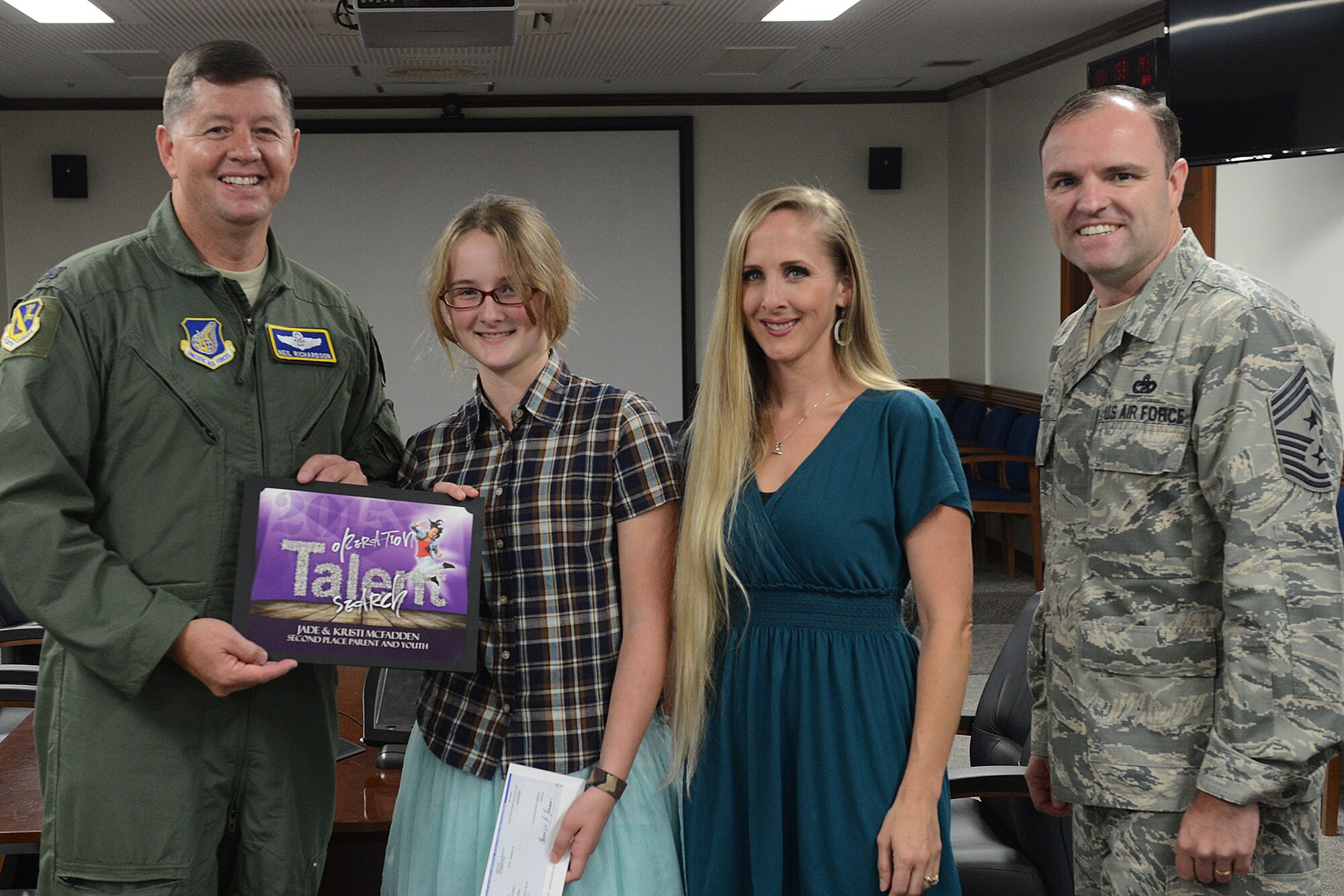 Col. Neil Richardson, 374th Airlift Wing vice commander, presents an 'Operation Talent Search' award to Kristi McFadden, spouse of Special Agent Jeramis McFadden, Office of Special Investigations 6th Field Investigations Squadron, and her daughter, Jade McFadden, age 12, at Yokota Air Base, Japan, Aug. 24, 2015. The McFaddens placed second in the parent and youth division at Air Force level. (U.S. Air Force photo by Senior Airman David C. Danford/Released)
