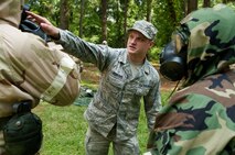 Senior Airman Timothy Roberts, 4th Civil Engineer Squadron emergency management personnel, instructs Airmen on proper war of the gas mask during an Ability to Survive and Operate (ATSO) exercise, Aug. 25, 2015, at Seymour Johnson Air Force Base, North Carolina. After donning all mission-oriented protective posture gear, Airmen were required to perform buddy-checks to ensure everyone was properly outfitted. (U.S. Air Force photo/Master Sgt. Jocelyn L. Rich-Pendracki)