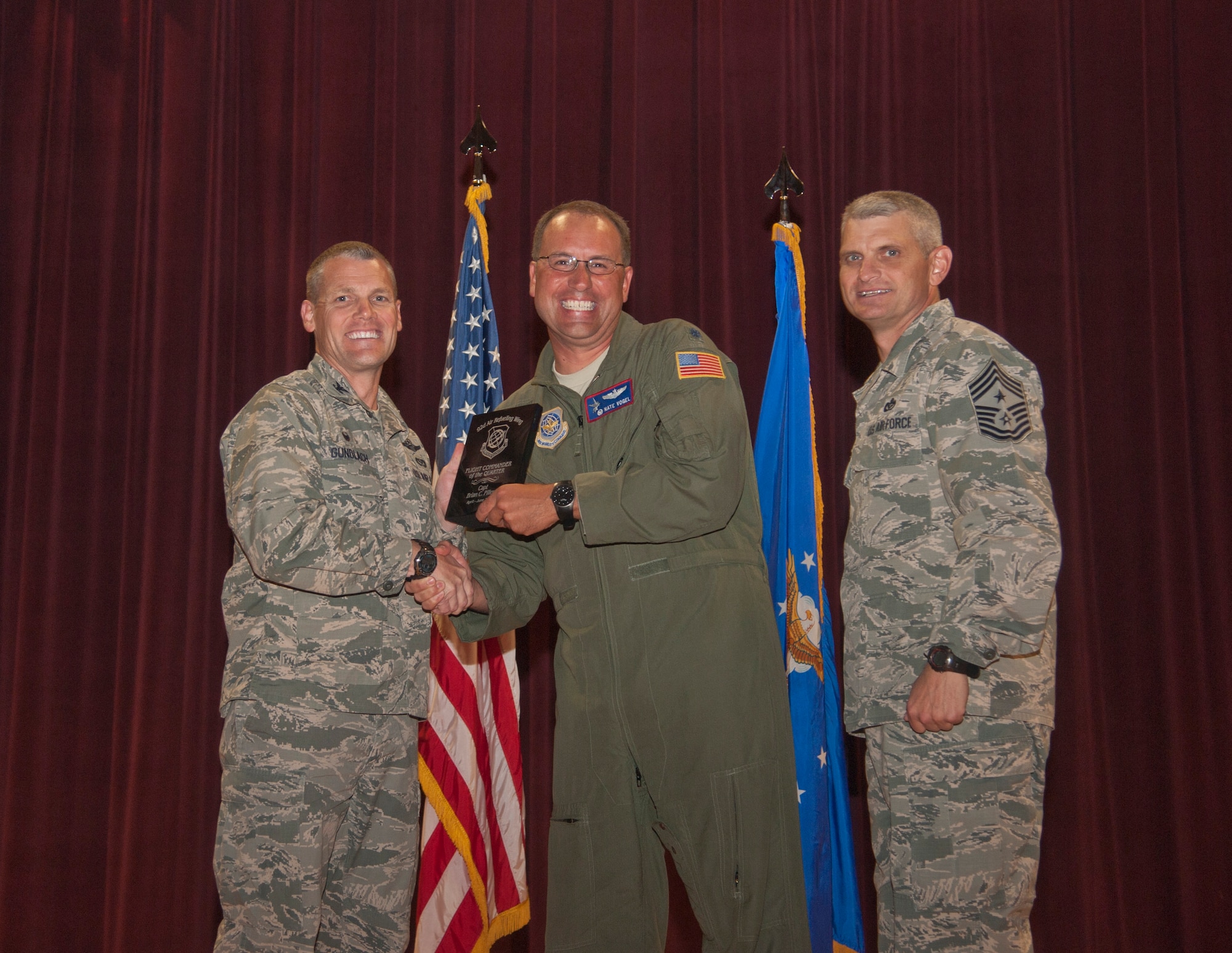 Lt. Col. Nate Vogel accepts the 92nd Air Refueling Wing Flight Commander of the Quarter award on behalf of Capt. Brian Pillers, 93rd Air Refueling Squadron scheduling flight commander, Aug. 24, 2015, at Fairchild Air Force Base, Wash. (U.S. Air Force photo/Airman 1st Class Taylor Bourgeous)