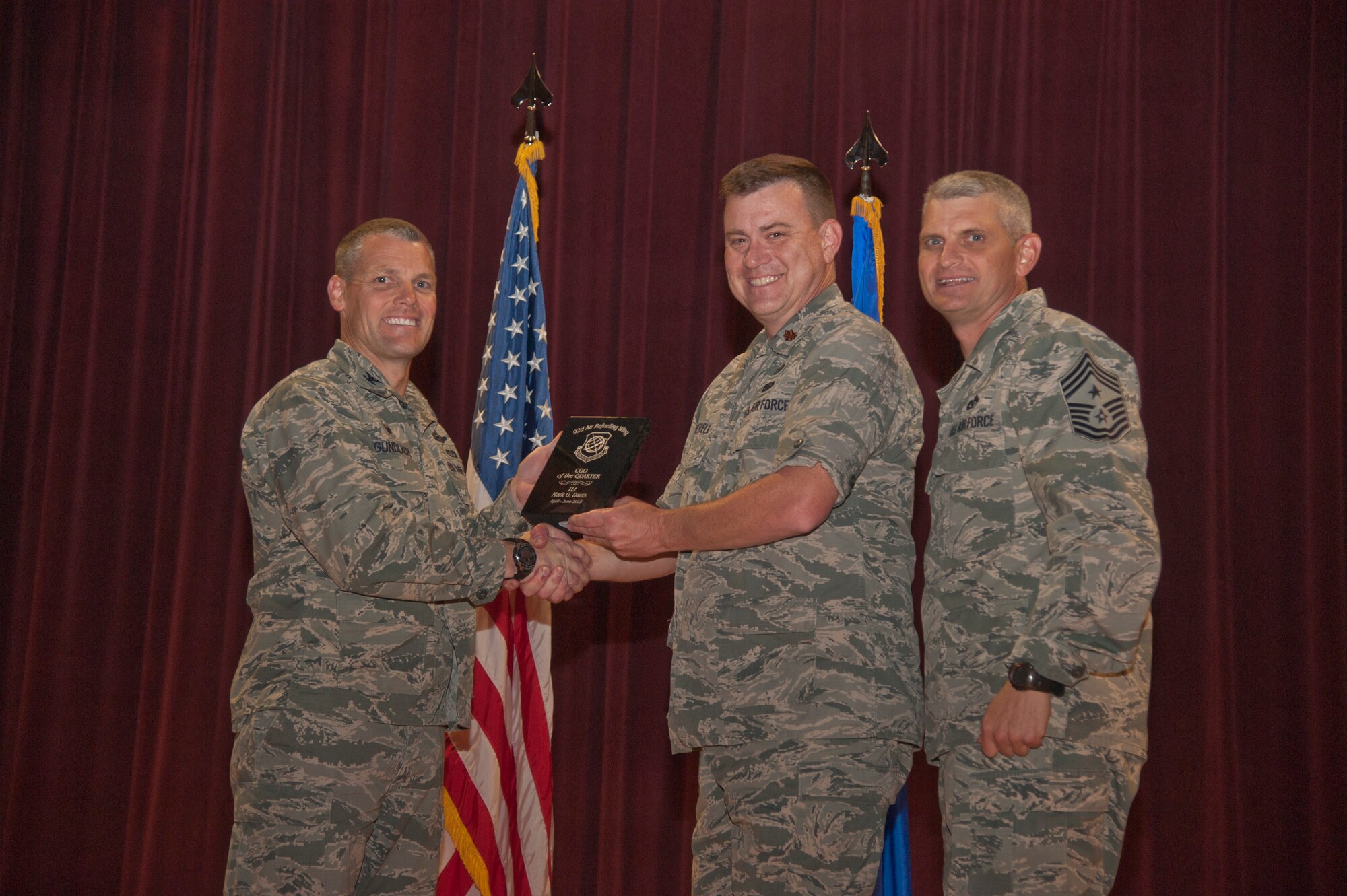 Maj. James Cantrell accepts the 92nd Air Refueling Wing Company Grade Officer of the Quarter award on behalf of 1st Lt. Mark Davis, 92nd Operations Support Squadron chief of the intelligence training element, Aug. 24, 2015, at Fairchild Air Force Base, Wash. (U.S. Air Force photo/Airman 1st Class Taylor Bourgeous)