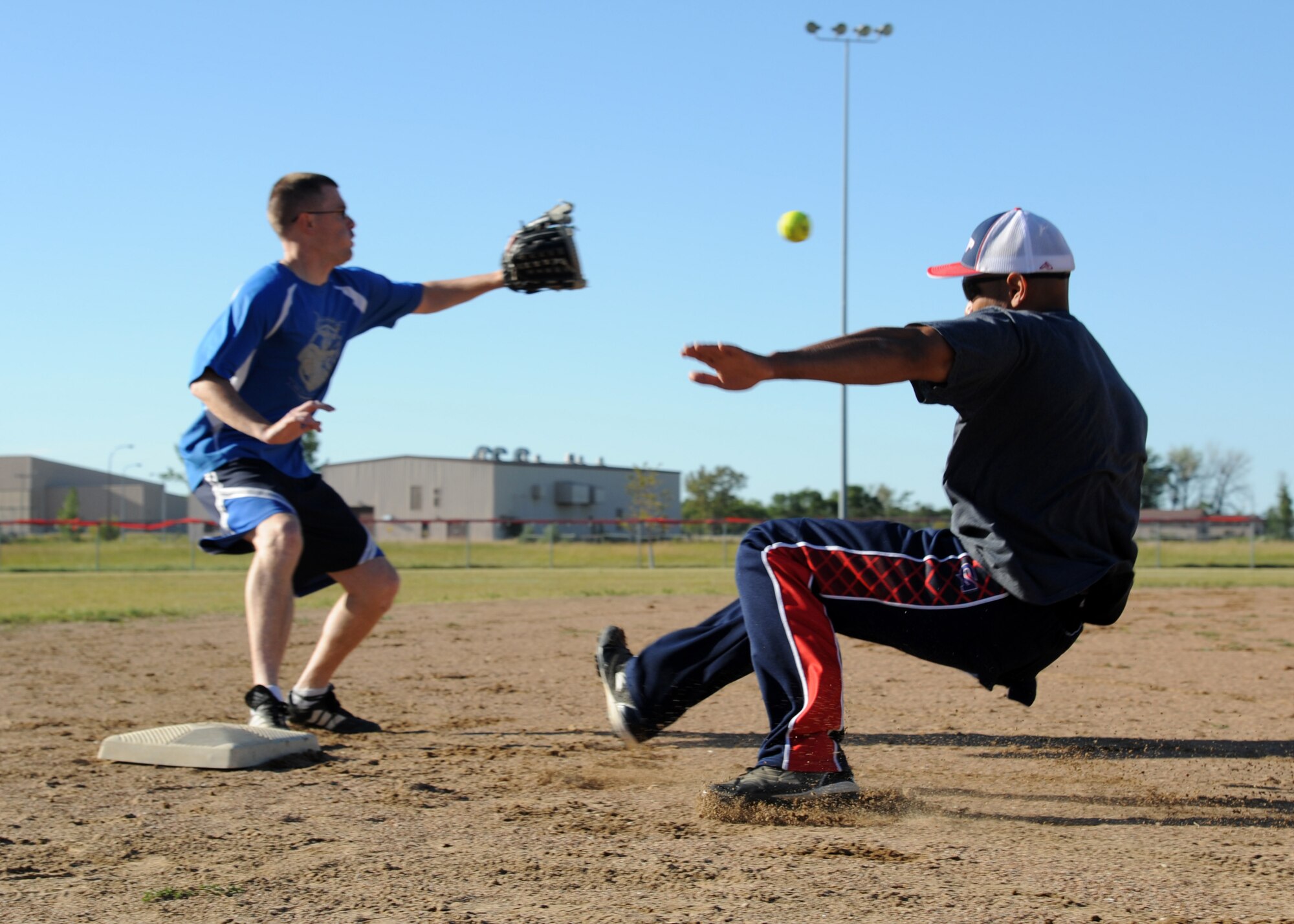 Capt. Leandro De Los Santos, 348th Reconnaissance Squadron chief of training, slides into third base during the Intramural Softball Championship game August 24, 2015, on Grand Forks Air Force Base, North Dakota. De Los Santos played second base for the 69th Reconnaissance Group team who won the championship. (U.S. Air Force photo by Airman 1st Class Ryan Sparks/Released)