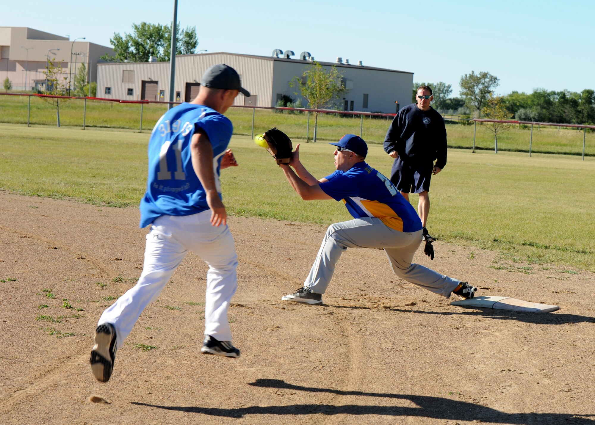 Tech. Sgt. Adam Ledwozan, 69th Maintenance Squadron quality assurance inspector, catches the ball for an out during the Intramural Softball Championship game August 24, 2015, on Grand Forks Air Force Base, North Dakota. Ledwozan played first base for the 69th Reconnaissance Group team who won the championship. (U.S. Air Force photo by Airman 1st Class Ryan Sparks/Released)
