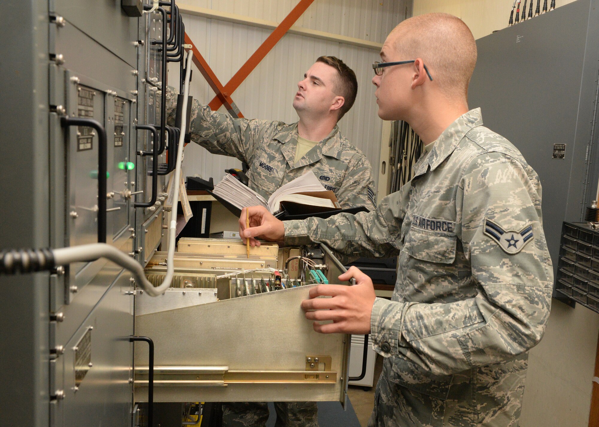 ALTUS AIR FORCE BASE, Okla. – U.S. Air Force Staff Sgt. Matthew Moore and Airman 1st Class Nathanniel Cones, 97th Operations Support Squadron airfield systems technicians, perform a 100-watt alignment on the transponder for the tactical Air Navigation System, Aug. 24, 2015. The alignment is important so the system does not give erroneous readings, which could cause equipment shutdown and endanger aircraft. (U.S. Air Force photo by Airman 1st Class Megan E. Acs/Released)
