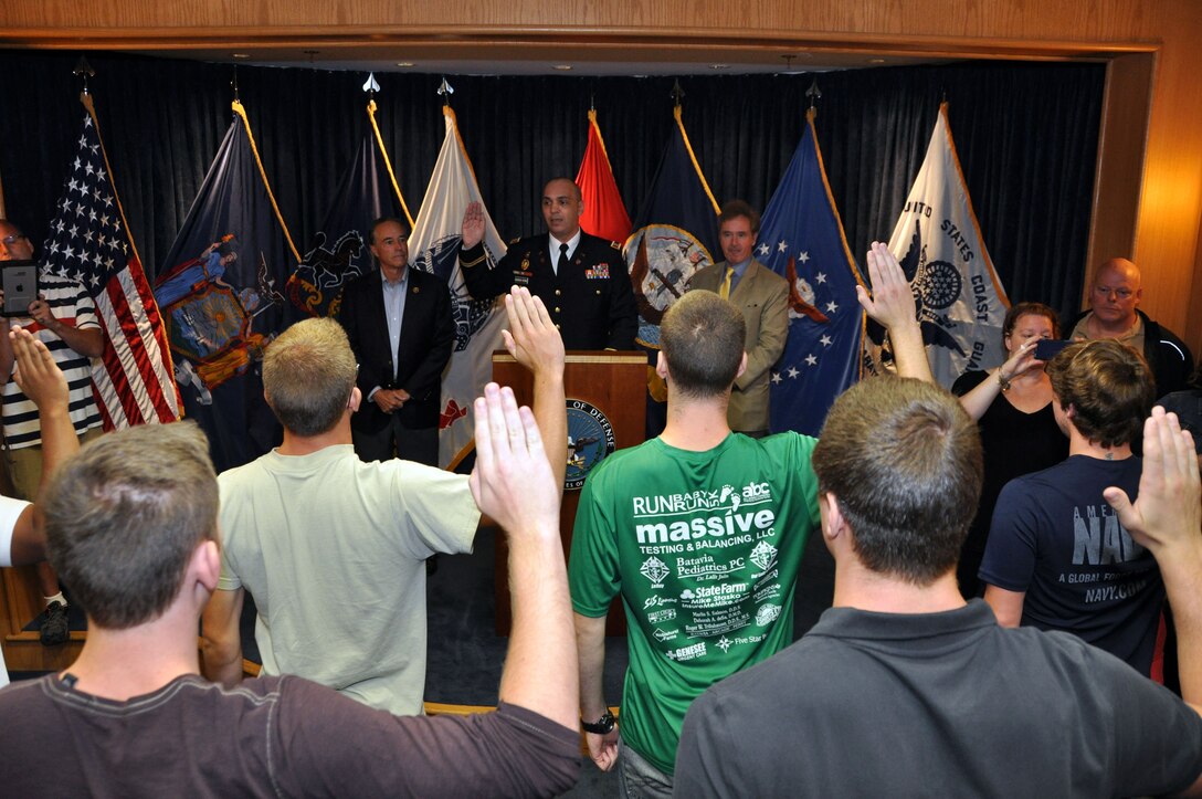 Capt. Marcel Bolboaca-Negru, Operations Officer for the Buffalo Military Entrance Processing Station, is flanked by Congressmen Chris Collins (NY-27) (left) and Congressman Brian Higgins (NY-26) as he administers the Oath of Enlistment to several individuals at the Niagara Falls Air Reserve Station, N.Y. August 25, 2015.  These military service trainees will now journey to their respective basic training sites.  (U.S. Air Force photo by Master Sgt. Kevin Nichols)