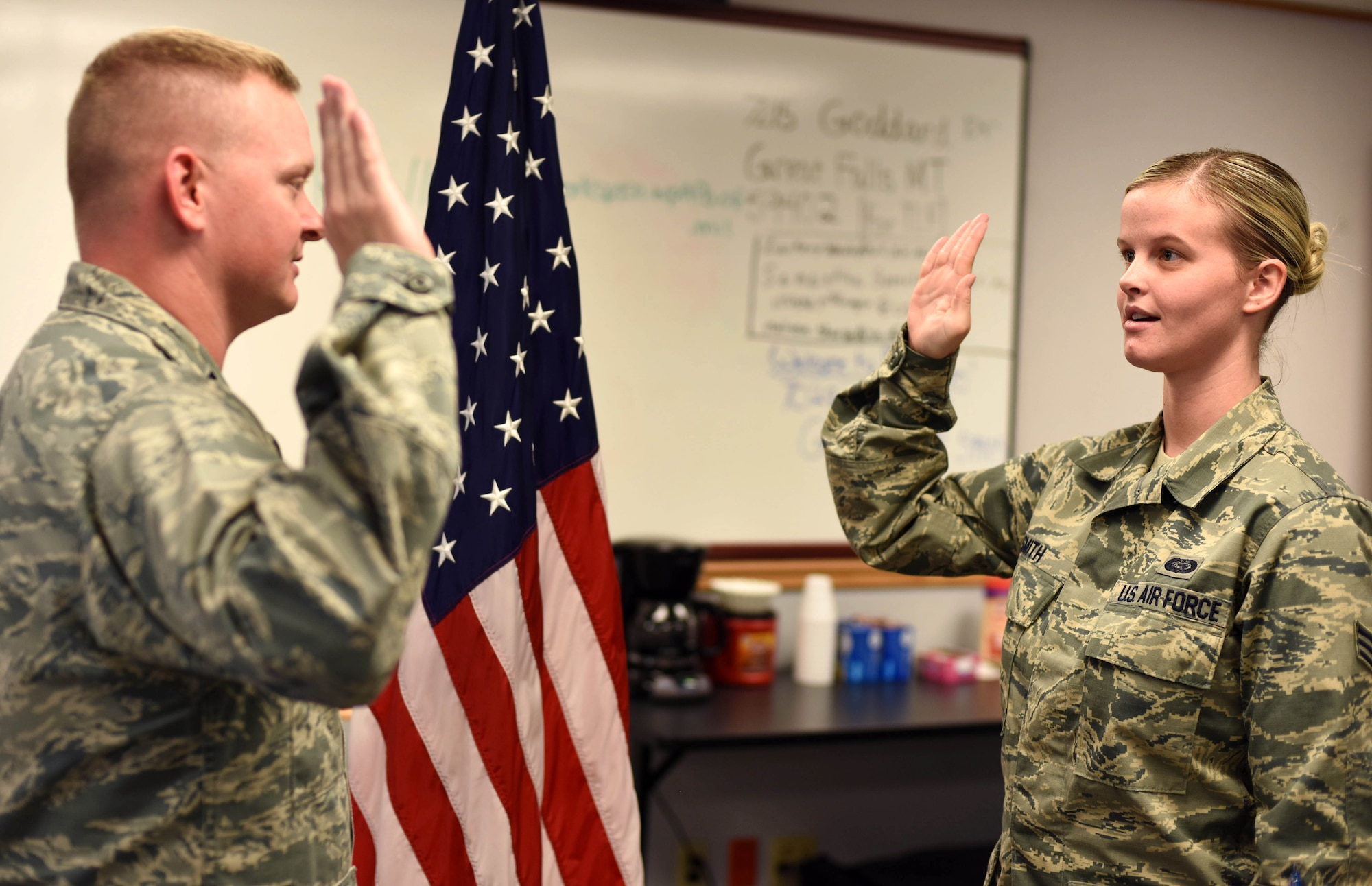 Senior Airman Jessica Smith, 341st Force Support Squadron force management journeyman, right, recites the Oath of Enlistment during a practice ceremony at Malmstrom Air Force Base, Mont., Aug. 24. Capt. Phillip Martin, 341st FSS operations officer, presides over the ceremony. (U.S. Air Force photo Airman 1st Class Collin Schmidt) 
