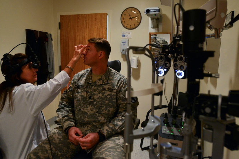 Dr. Robin Collard, McDonald Army Health Center Eye Clinic optometrist, uses a 20 diopter lens during U.S. Army Col. Glenn Hodges’, U.S. Army Training and Doctrine Command Army Capabilities Integration Center human performance and learning analyst, annual eye exam at Fort Eustis, Va.  Aug. 21, 2015. She used the lens to examine the patient’s surrounding retina for abnormalities after having his eye’s dilated and checked for glaucoma. (U.S. Air Force photo by Staff Sgt. Natasha Stannard/Released)