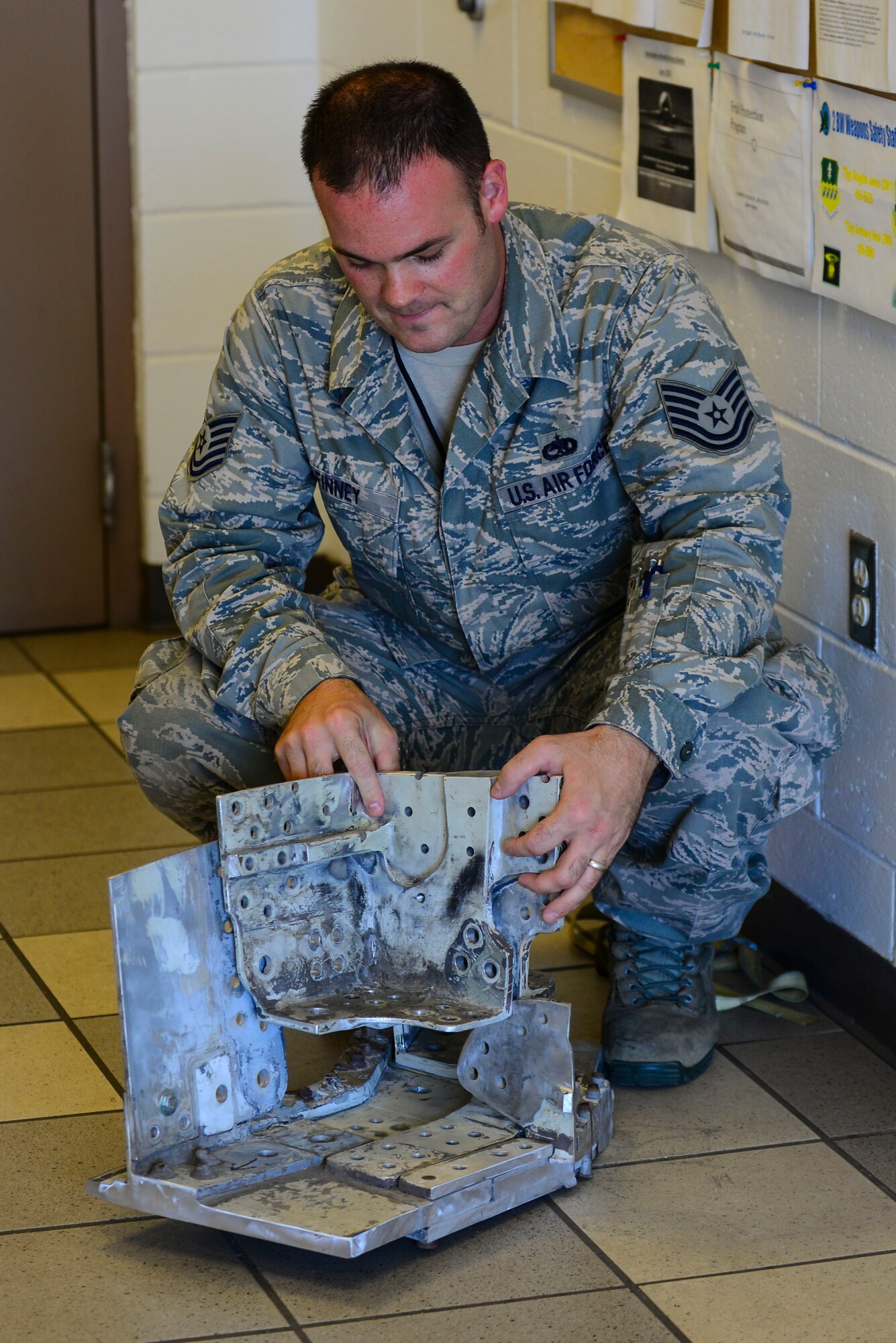 Tech. Sgt. Aaron Finney, 2nd Maintenance Squadron fuels systems NCO in-charge, examines part of a fuel tank at Barksdale Air Force Base, La., August 21, 2015. The tank part was taken from an older aircraft so aircraft mechanics are better able to plan and discuss the repair operation before entering the aircraft compartment that houses the fuel. (U.S. Air Force photo/Senior Airman Benjamin Raughton)
