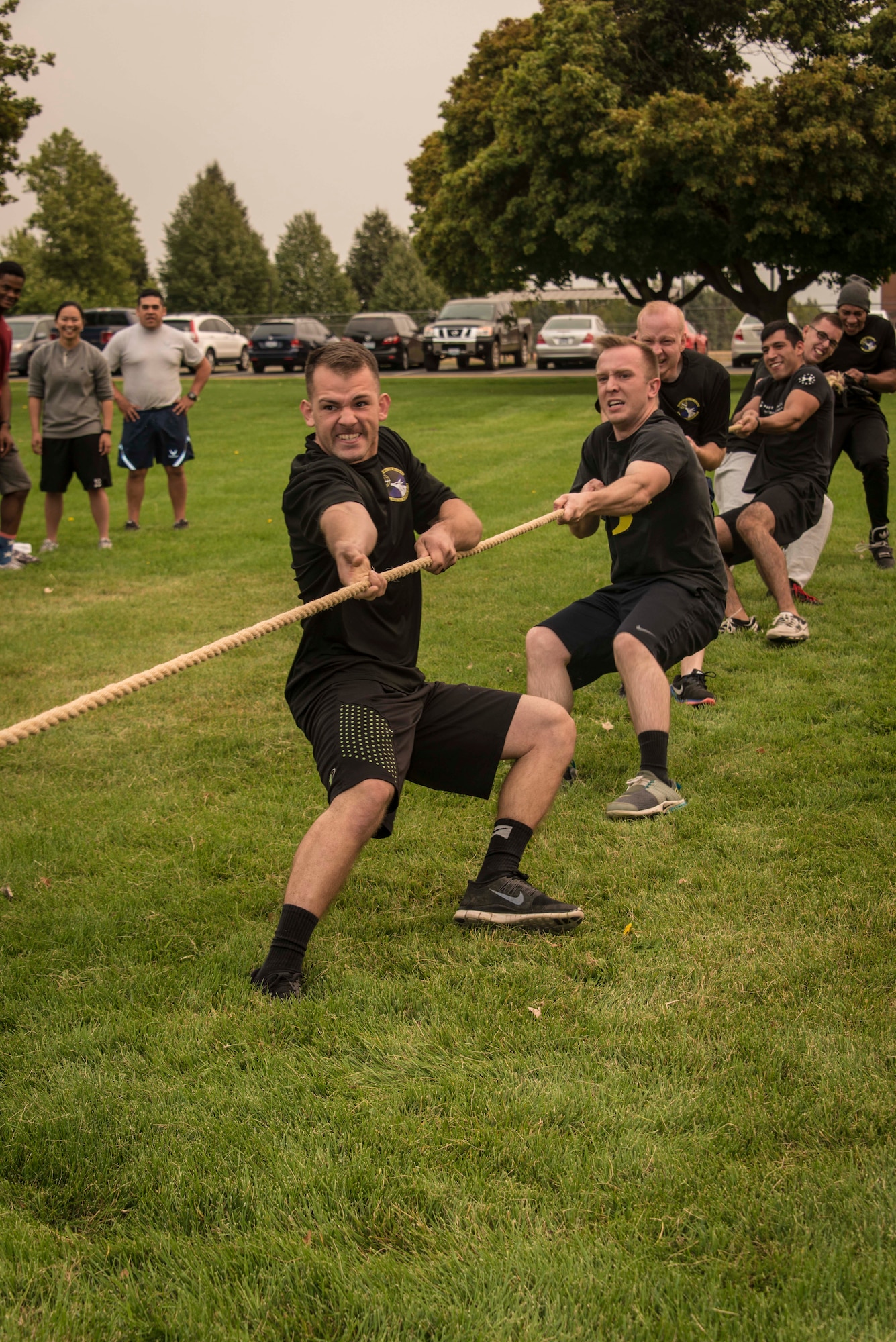 Airmen from the 92nd Logistics Readiness Squadron eke out a victory as they pulled their way through the tug of war competition during Summer Sports Day Aug. 20, 2015, at Fairchild Air Force Base, Wash. Tug of war is a sport that directly puts two or more teams against each other in a test of strength: teams pull on opposite ends of a rope, with the goal being to bring the rope a certain distance in one direction. Events like Summer Sports Day are tools commanders use to improve unit morale and readiness. (U.S. Air Force photo/Staff Sgt. Benjamin W. Stratton)