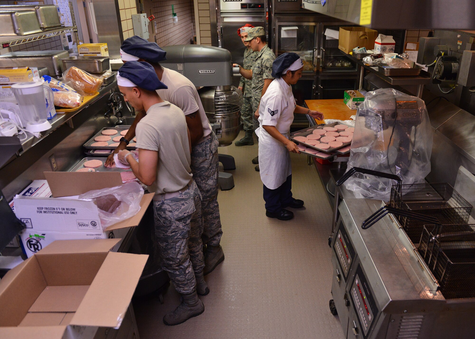 U.S. Air Force food services Airmen prepare hamburgers for the dinner rush Aug. 18, 2015, during RED FLAG-Alaska (RF-A) 15-3 at the Two Seasons Dining Facility on Eielson Air Force Base, Alaska. During RF-A, the facility dishes out more than 1,400 meals per day, three times its normal support rate of 300 to 400 meals. (U.S. Air Force photo by Airman 1st Class Kyle Johnson/Released)
