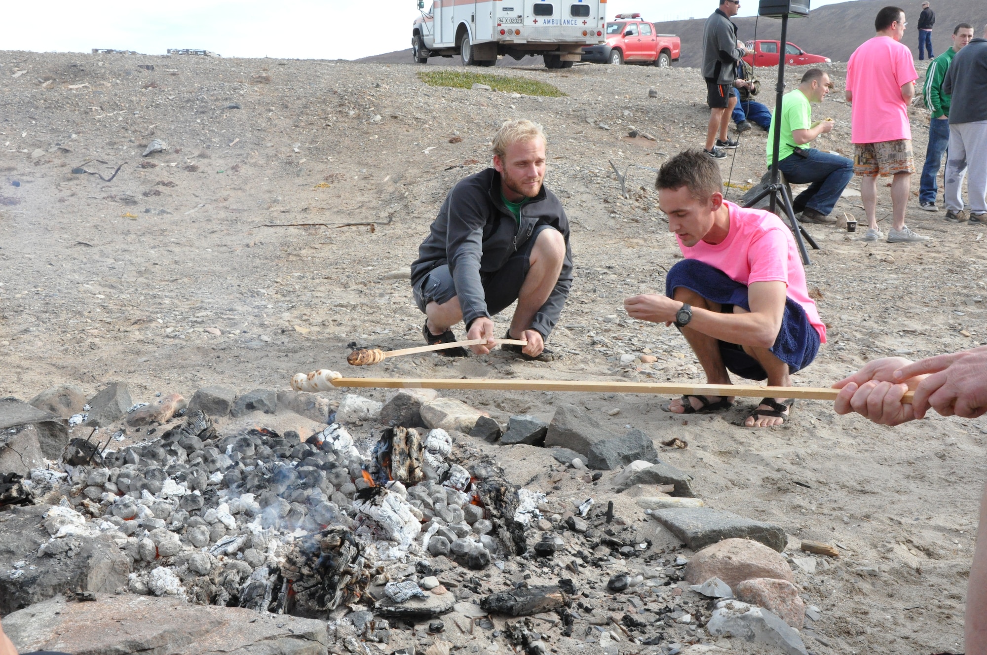THULE AIR BASE, Greenland – Merlin Yoder (left), a pilot with Dynamic Aviation, and 2nd Lt. Nathan Briggs, 12th Space Warning Squadron crew commander and chief of maintenance, toast traditional Danish bread over a bonfire Aug. 15 following the polar bear plunge. Dozens of Airmen, contractors and temporary duty personnel braved the frigid water in the annual dip into North Star Bay. Thule is one of the six installations operated by the 21st Space Wing, and is located 750 miles north of the Arctic Circle. (U.S. Air Force photo by Steve Brady)