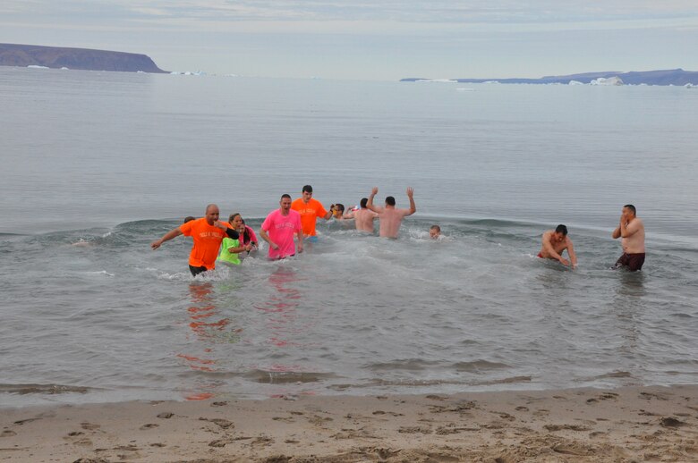 THULE AIR BASE, Greenland –With icebergs floating in the distance, Airmen from the 12th Space Warning Squadron brave the frigid water in the annual Thule polar bear plunge Aug. 15, 2015. The traditional plunge into North Star Bay is held each summer when the bay is not frozen, and while Thule is experiencing 24 hours of light each day. Thule is one of the six installations operated by the 21st Space Wing, and is located 750 miles north of the Arctic Circle. (U.S. Air Force photo by Steve Brady)