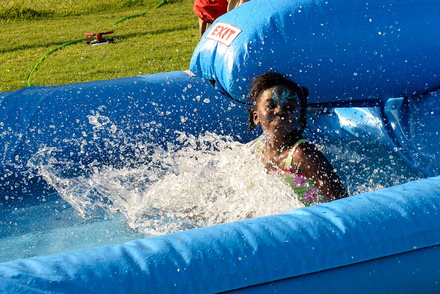 A member of Team Seymour splashes down a water slide during the Independence Day Celebration and Back to School Bash, Aug. 21, 2015, at Seymour Johnson Air Force Base, North Carolina. An entire play zone with games and bounce houses was available for kids to enjoy during the event. (U.S. Air Force photo/Airman 1st Class Ashley Williamson)