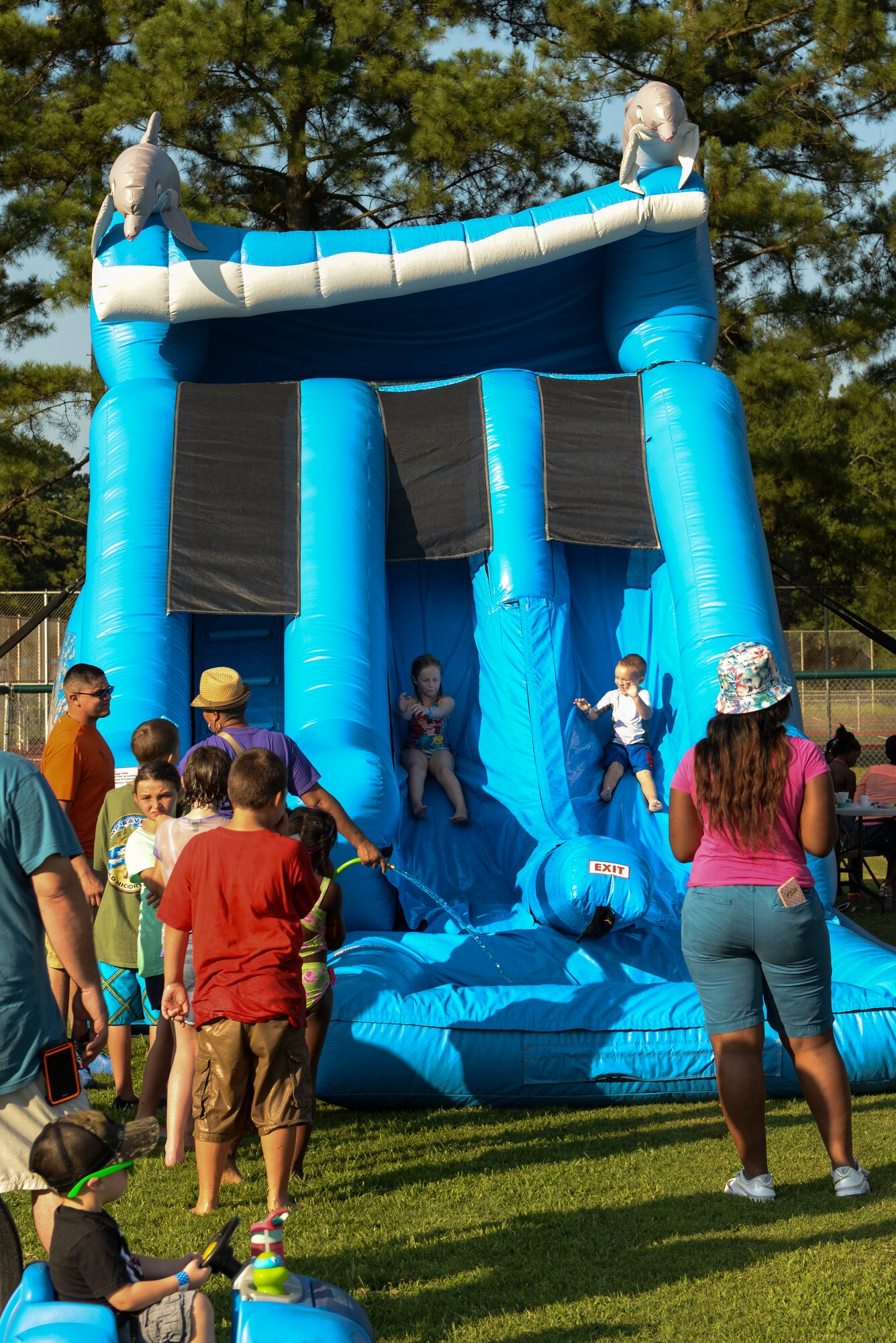 Members of Team Seymour ride down a water slide during the Independence Day Celebration and Back to School Bash, Aug. 21, 2015, at Seymour Johnson Air Force Base, North Carolina. The event featured live music, food, family games, and fireworks. (U.S. Air Force photo/Airman 1st Class Ashley Williamson)