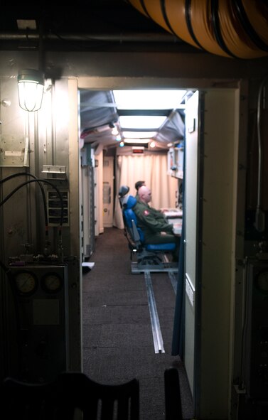 Maj. Tom Perry and 1st Lt. Jonathon Powell, 320th Missile Squadron missile combat crew members, perform the daily missileer routines Aug. 21, 2015, inside a launch control center. Crews of two missileers man each launch control center for 24 hours before being replaced by another crew. (U.S. Air Force by Airman 1st Class Brandon Valle)