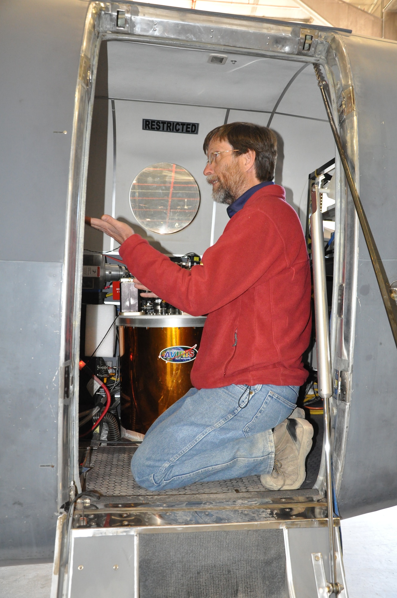 THULE AIR BASE, Greenland – Robert Green, a scientist and senior research engineer with NASA’s Jet Propulsion Laboratory, explains the AVIRIS imaging spectrometer Aug. 16, 2015 at Thule Air Base. The spectrometer was used to measure the ice sheet covering Greenland to develop software for ICESat-2 due to launch in 2017. The researchers relied on the 821st Air Base Group to provide a hangar, lodging, meals and more while they conducted three weeks of research in the Arctic Circle. The 821st ABG, one of the six installations operated by the 21st Space Wing, maintains an airfield and 10,000-foot runway at the U.S. Armed Forces' northernmost installation. (U.S. Air Force photo by Steve Brady)