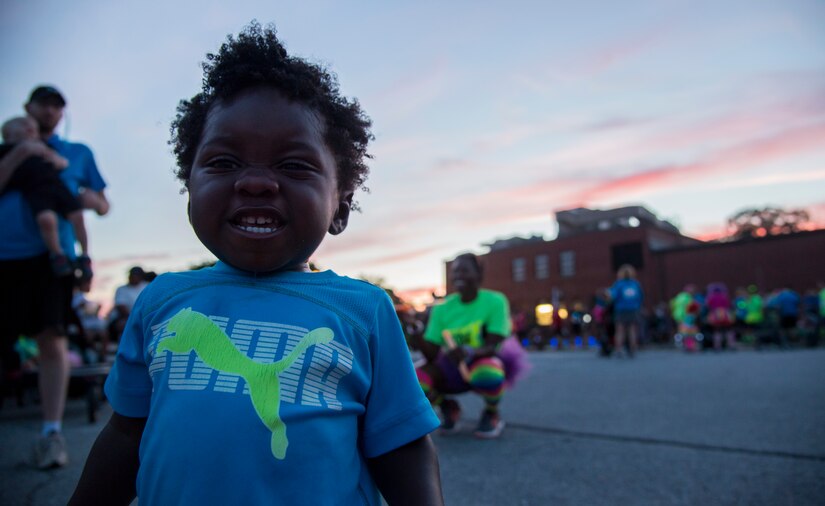 One-year-old Maxwell Whitehurst smiles prior to the Ready.Set.Glow 5k outside the Community Commons on Joint Base Andrews, Md., Aug. 21, 2015. Parents and their kids took part in the event with many parents running with jogging strollers.  (U.S Air Force photo/Airman 1st Class Philip Bryant)