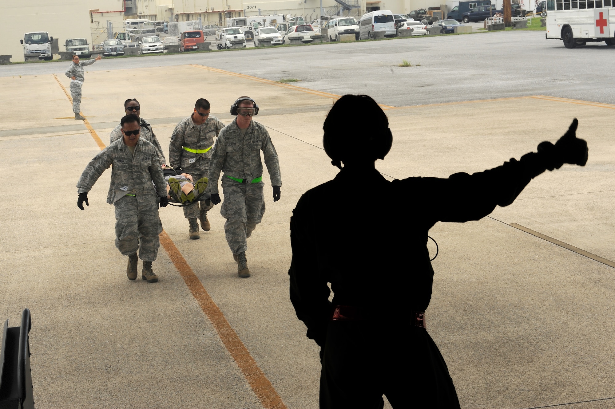 U.S. Air Force Capt. Tracie Coy, 8th Aeromedical Evacuation Squadron nurse, directs a team from the 18th Medical Group carrying a simulated patient into a C-130 on Kadena Air Base, Japan, Aug. 18, 2015. Coy, who is assigned to Misawa Air Base, was at Kadena participating in an En-Route Patient Staging System exercise, which simulated a situation necessitating the evacuation of injured personnel from Kadena Air Base. (U.S. Air Force photo by Airman 1st Class Zade C. Vadnais)