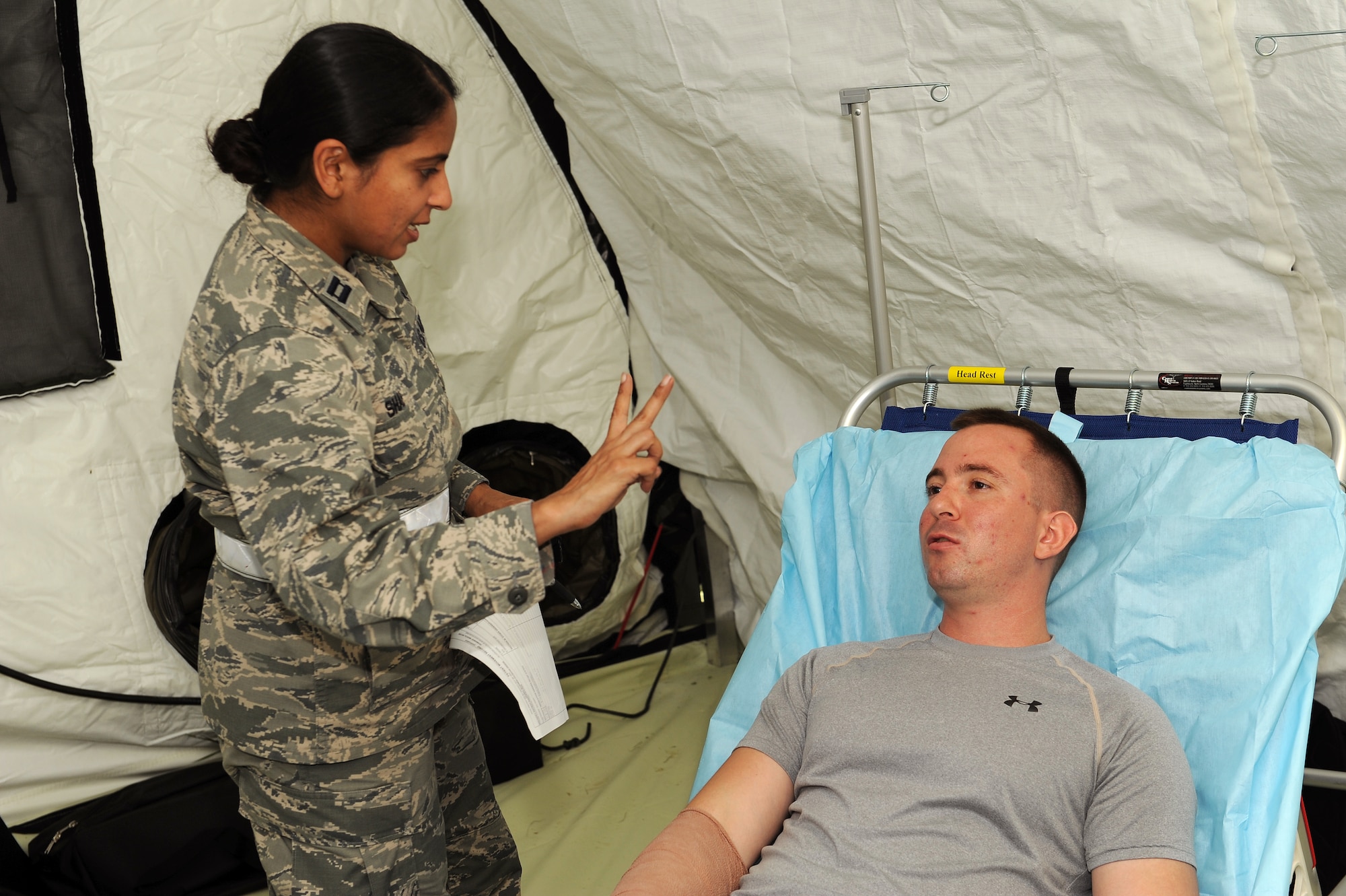 U.S. Air Force Capt. Pina Shah, 18th Medical Group clinical nurse, conducts a vision test on a mock patient to see how responsive he is after a simulated injury on Kadena Air Base, Japan, Aug. 18, 2015. Medical personnel from Misawa Air Base, Japan, Joint Base Lewis-McChord, Wash., and Camp Bullis, Texas supported the En-Route Patient Staging System exercise hosted by Kadena’s 18th Wing. (U.S. Air Force photo by Airman 1st Class Zade C. Vadnais)