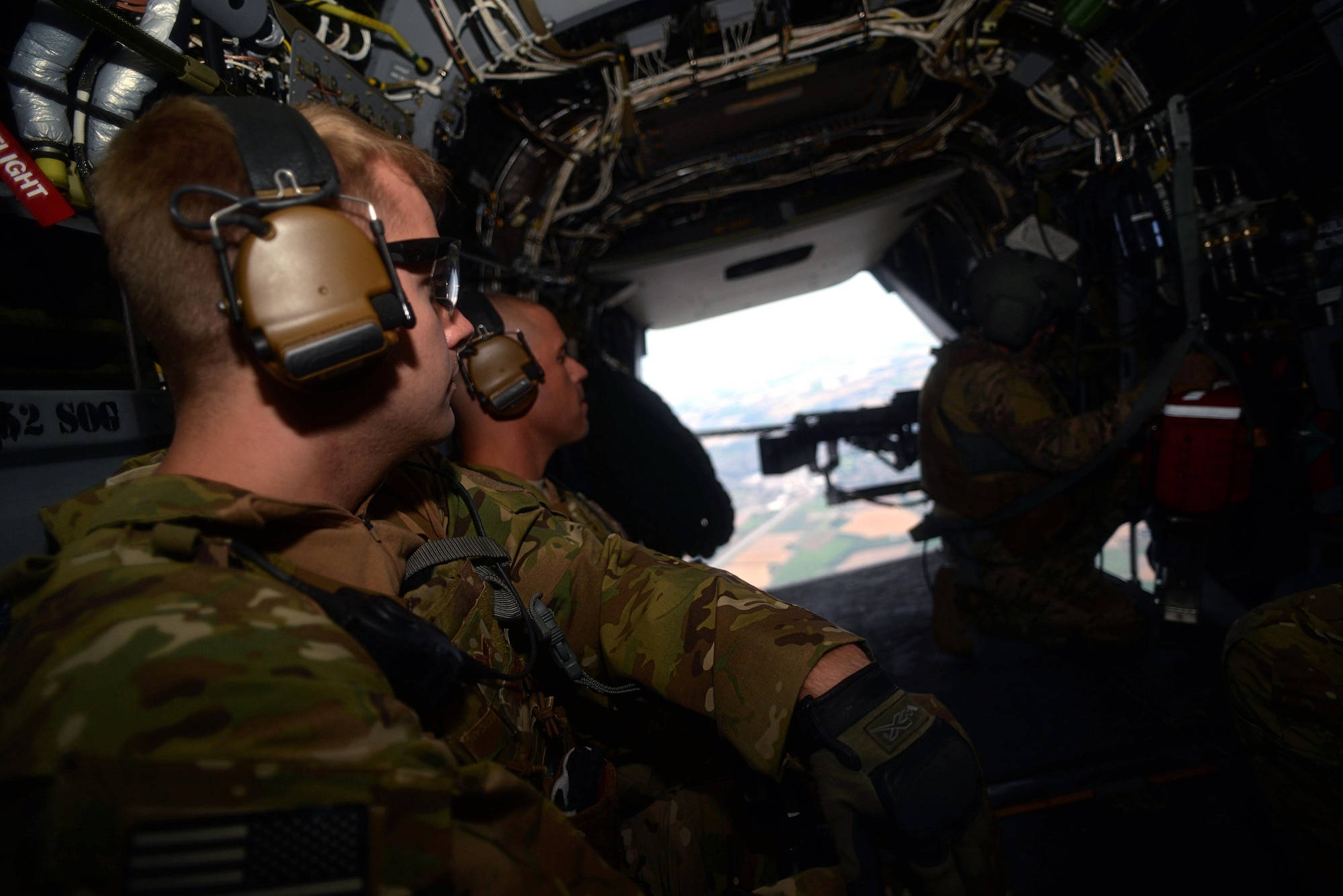U.S. Air Force Senior Airman Travis Dorsey, left, 352nd Special Operations Support Squadron Deployed Aircraft Ground Response Element team member from Little Rock, Ark., and U.S. Air Force Master Sgt. Shane Gullick, 352nd SOSS DAGRE team lead from Memphis, Tenn., watch as U.S. Air Force Adam Vogt, 7th Special Operations Squadron CV-22 Osprey Flight Engineer from Motley, Minn., prepares a hoisting device for use Aug. 21, 2015, over England. The team was participating in Exercise Jackal Stone during which their objective was to recover an isolated DoD Contractor. (U.S. Air Force photo by Senior Airman Christine Halan/Released)
