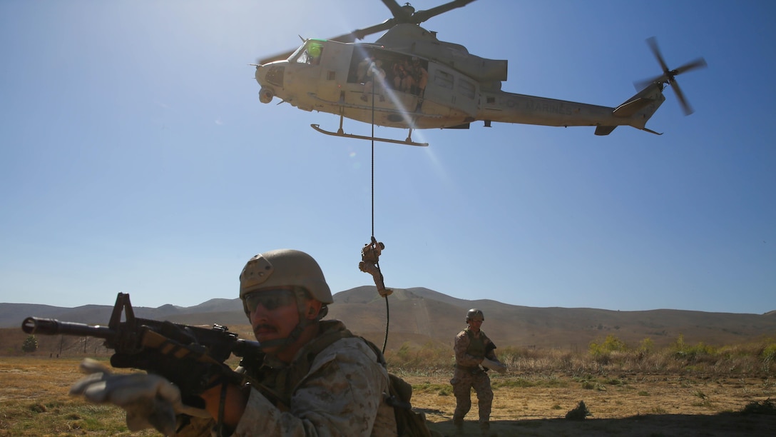 A Marine with Company A, 1st Reconnaissance Battalion, 1st Marine Division, I Marine Expeditionary Force, provides security for his fellow Marines at the drop zone of a fast-roping exercise on Marine Corps Base Camp Pendleton, Calif., Aug 18, 2015. Utilizing both fast-roping and Special Patrol Insertion and Extraction rigging methods, the purpose of the training exercise was to integrate operational coordination between the I MEF Ground Combat Element and Air Combat Element. 