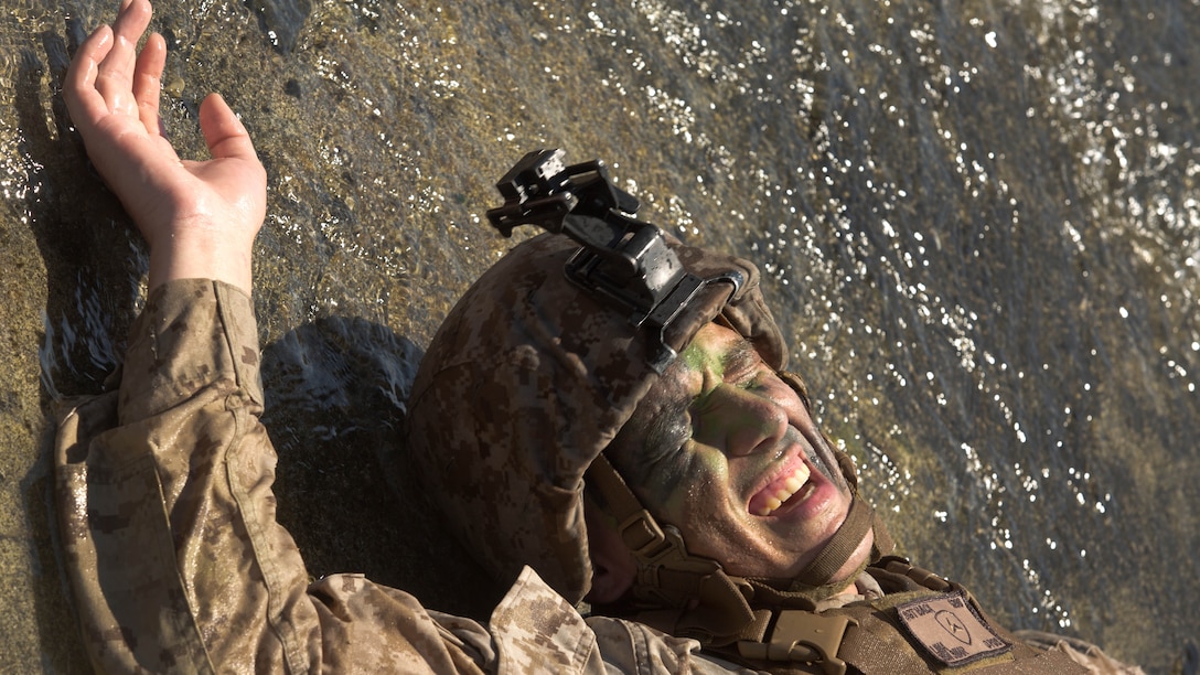 Sgt. Phillip Baca, an infantry squad leader with 3rd Battalion, 3rd Marine Regiment and a Barstow, Calif., native, writhes in agony as a cramp grips his leg and he works to straighten it out while low crawling along Fort Hase Beach aboard Marine Corps Base Hawaii during Sergeants Course Aug. 19, 2015. Baca, along with other sergeants in the course, low crawled in a tricky scenario where they were outnumbered four to one, and needed to repair a broken down vehicle. Sergeants Course is a vital part of professional military education for any Marine and helps to maintain the standards amongst the NCOs of the Marine Corps. The course supports MCB Hawaii’s mission, which is to provide facilities, programs and services in direct support of units, individuals and families to enhance and sustain combat readiness for all operating forces and tenant organizations aboard the installation.