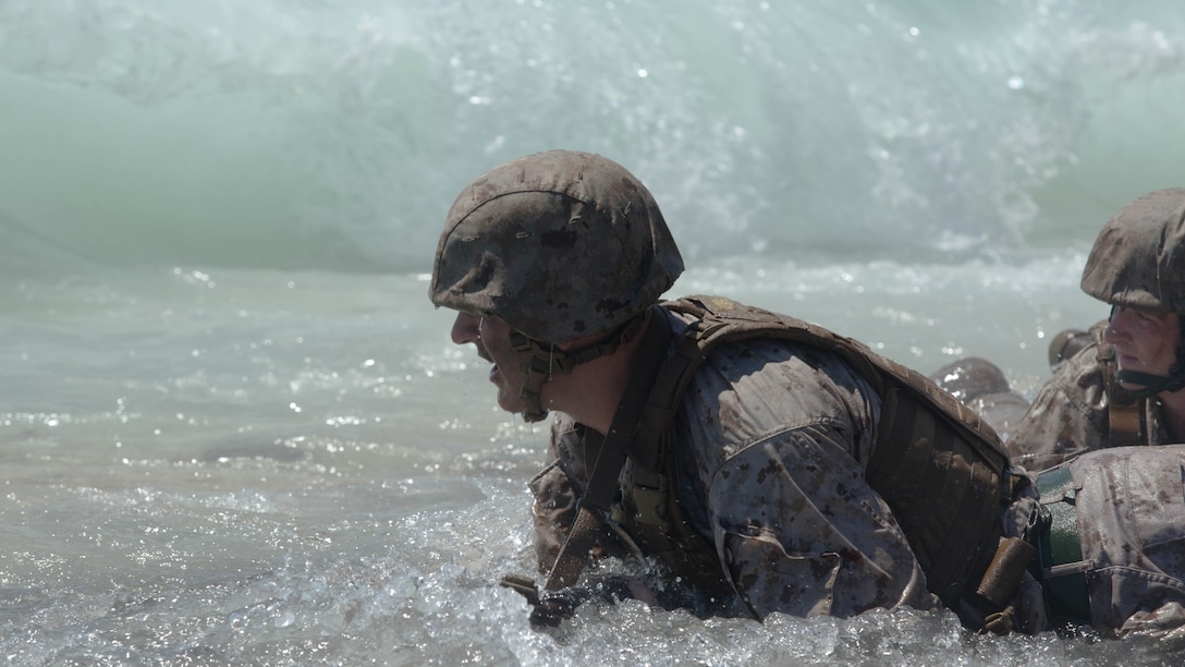 Sgt. Brett Oros, a food service specialist with Marine Wing Support Squadron 373 based out of Marine Corps Air Station Miramar and a Wallingford, Conn., native, braces himself as a wave builds itself to crash into him while he wades through the surf of Fort Hase beach aboard Marine Corps Base Hawaii during Sergeants Course Aug. 19, 2015. Oros, along with the other sergeants in the course, participated in a scenario where they were outnumbered 4 to 1, and needed to repair a broken down vehicle. Sergeants Course is a vital part of professional military education for any Marine and helps to maintain the standards amongst the NCOs of the Marine Corps. The course supports MCB Hawaii’s mission, which is to provide facilities, programs and services in direct support of units, individuals and families to enhance and sustain combat readiness for all operating forces and tenant organizations aboard the installation. 