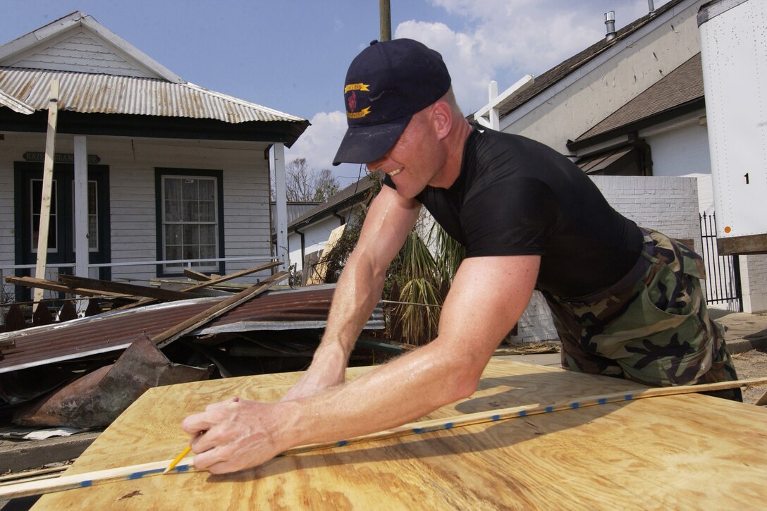 Air Force Senior Airman Martin Whalen prepares to cut a sheet of plywood to repair the roof of the Hancock County Historical Society building in Bay St. Louis, Miss., Sept. 20, 2005. Whalen is assigned to the 110th Civil Engineering Squadron. DoD photo by U.S. Air Force Senior Master Sgt. Thomas Meneguin