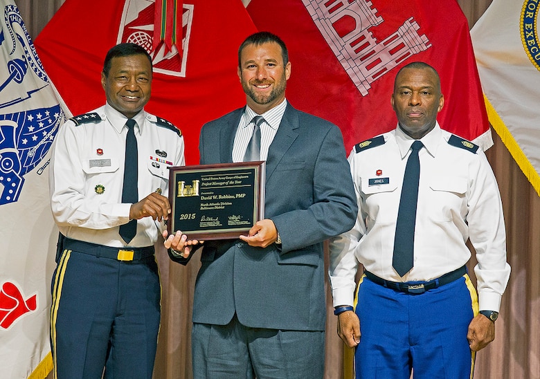 Lt. Gen. Thomas P. Bostick, U.S. Army, chief of engineers, presents Dave Robbins, Baltimore District geographer and study manager, with the 2015 Project Manager of the Year award at the U.S. Army Corps of Engineers National Awards Ceremony, held at the Government Accountability Office in Washington, D.C., Aug. 6, 2015. Command Sgt. Maj. Antonio S. Jones, U.S. Army Corps of Engineers (right), is also pictured. (U.S. Army Photo by Jhi Scott)
