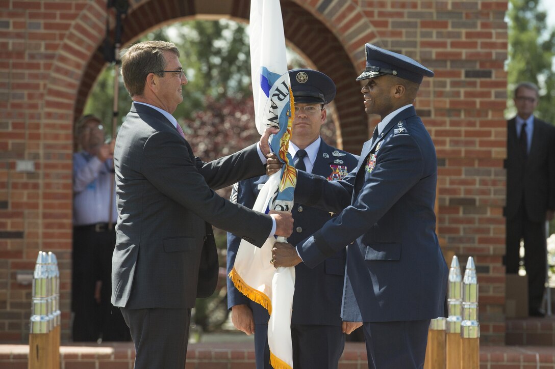 Defense Secretary Ash Carter hands the U.S. Transportation Command flag to Air Force Gen. Darren W. McDew as he assumed command during a ceremony on Scott Air Force Base, Ill., Aug. 26, 2015. 