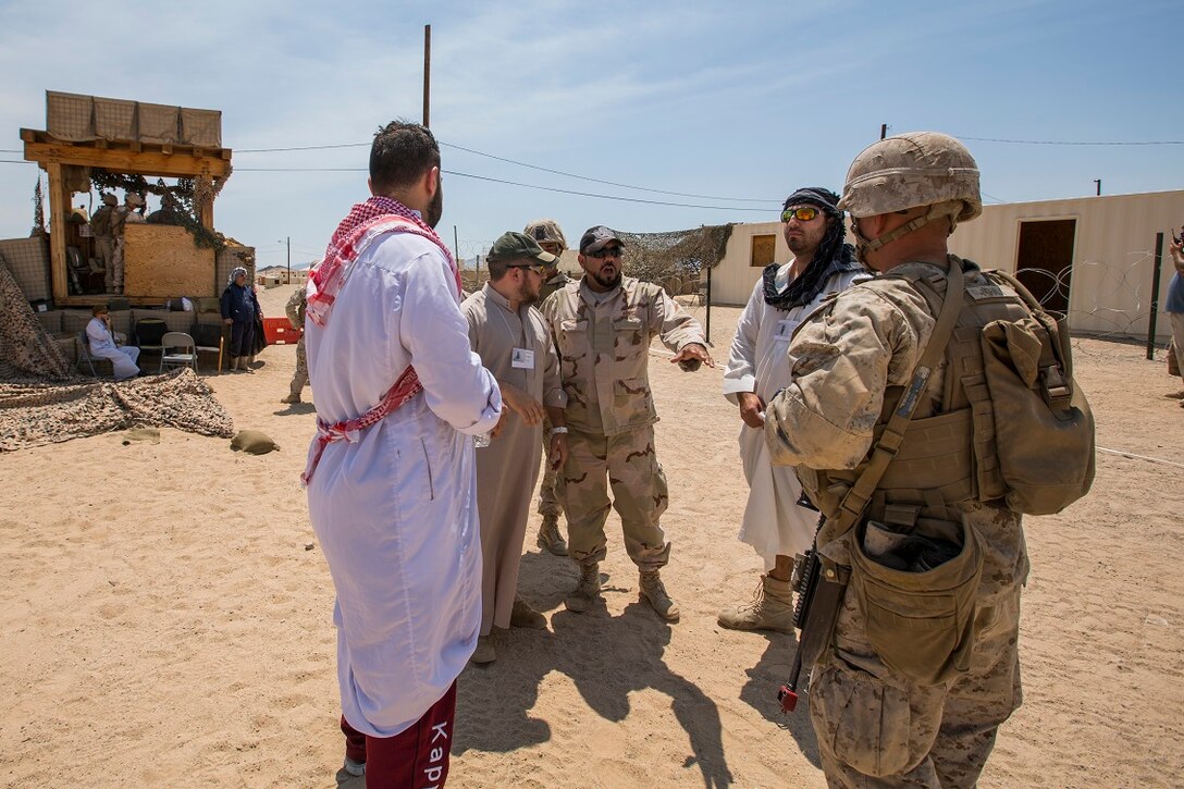 U.S. Marines with Company A, 1st Battalion, 7th Marine Regiment, interact with role players during a security force operations as a part of Large Scale Exercise (LSE) at Marine Corps Air Ground Combat Center Twentynine Palms, Calif., Aug. 18, 2015. LSE is a joint forces exercise conducted at the brigade level designed to enable live, virtual, and constructive training for participating units and allows participating nations to strengthen partnerships and their ability to operate together. (U.S. Marine Corps photo by Lance Cpl. Clarence A. Leake/Released)