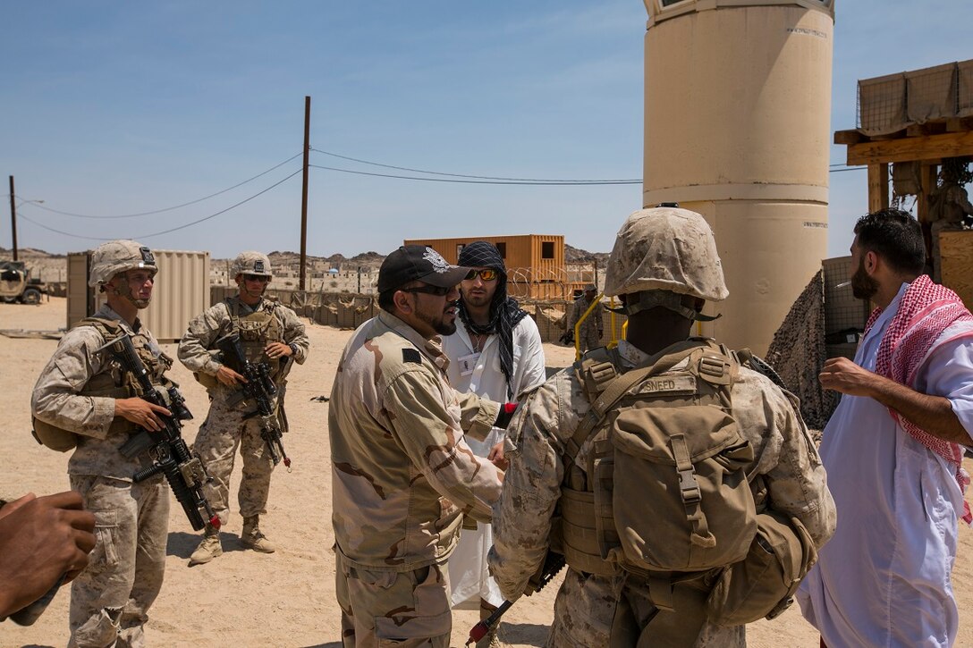 U.S. Marines with Company A, 1st Battalion, 7th Marine Regiment, interact with role players during a security force operations as a part of Large Scale Exercise (LSE) at Marine Corps Air Ground Combat Center Twentynine Palms, Calif., Aug. 18, 2015. LSE is a joint forces exercise conducted at the brigade level designed to enable live, virtual, and constructive training for participating units and allows participating nations to strengthen partnerships and their ability to operate together. (U.S. Marine Corps photo by Lance Cpl. Clarence A. Leake/Released)