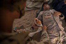 U.S. Navy Seaman Apprentice Isaac Montalvo, hospitalman with Company A, 1st Battalion, 7th Marine Regiment, renders medical aid to a simulated casualty during security force operations as a part of Large Scale Exercise (LSE) at Marine Corps Air Ground Combat Center Twentynine Palms, Calif., Aug. 18, 2015. LSE is a joint forces exercise conducted at the brigade level designed to enable live, virtual, and constructive training for participating units and allows participating nations to strengthen partnerships and their ability to operate together. (U.S. Marine Corps photo by Lance Cpl. Clarence A. Leake/Released)