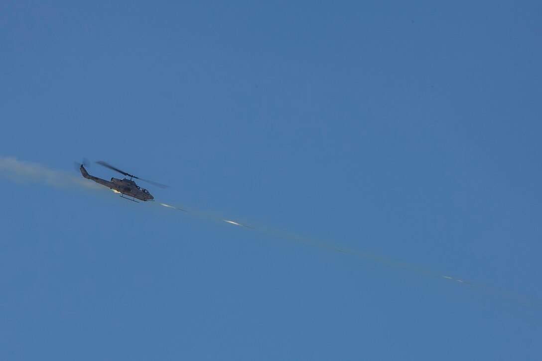 A U.S. Marine Corps AH-1W Super Cobra fires at simulated targets during a fire integration support team (FiST) exercise as a part of Large Scale Exercise (LSE) at Marine Corps Air Ground Combat Center Twentynine Palms, Calif., Aug. 16, 2015. LSE is a joint forces exercise conducted at the brigade level designed to enable live, virtual, and constructive training for participating units and allows participating nations to strengthen partnerships and their ability to operate together. (U.S. Marine Corps photo by Lance Cpl. Clarence A. Leake/Released)