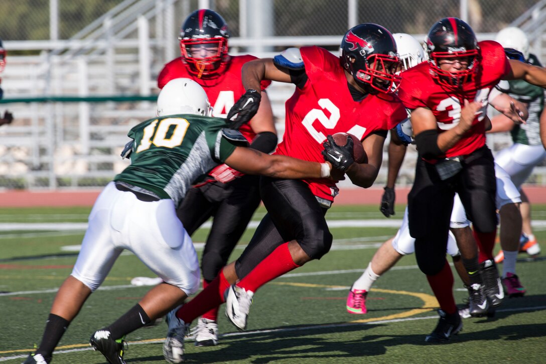 Cpl. Eric Campbell, a wide receiver for the Marine Corps Air Station Miramar Falcons, runs through the defense during a football game against the 1st Maintenance Battalion War Machines aboard Marine Corps Base Camp Pendleton, California, Aug. 24. The Miramar Falcons won the game with a score of 35-0. (U.S. Marine Corps photo by Cpl. Alissa P. Schuning/Released) 