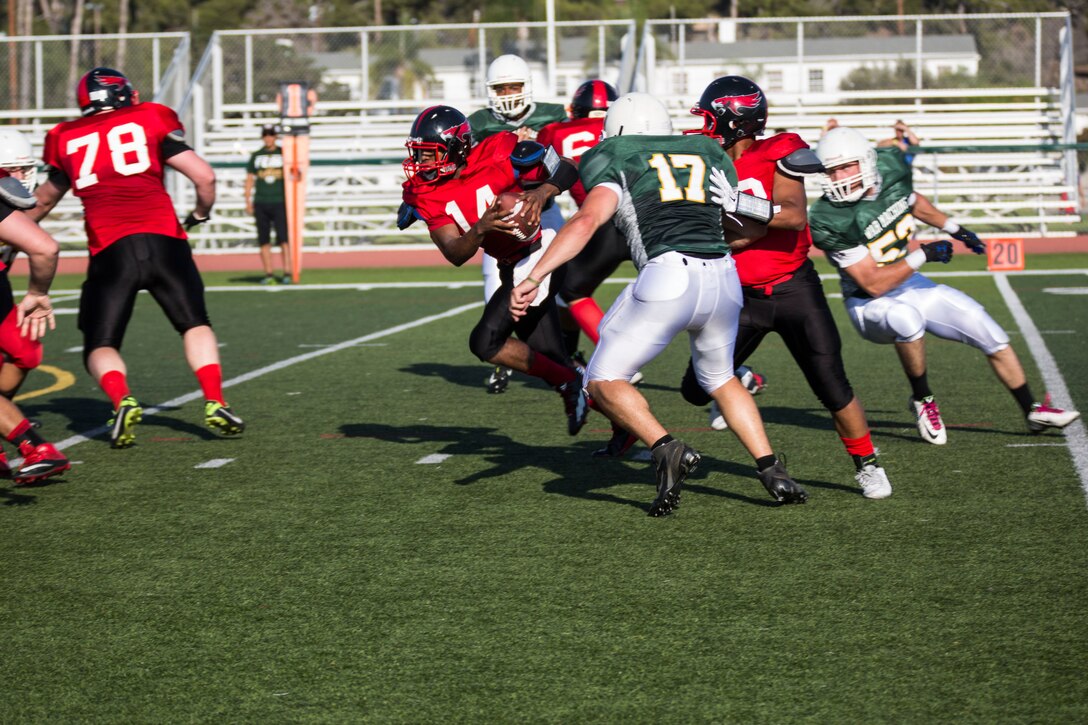 Lance Cpl.  Reginald Cooper, a quarterback for the Marine Corps Air Station Miramar Falcons, runs the ball during the first game of the season against the 1st Maintenance Battalion War Machines aboard Marine Corps Base Camp Pendleton, California, Aug. 24.The Falcons beat the War Machines 35 - 0. (U.S. Marine Corps photo by Cpl. Alissa P. Schuning/Released)