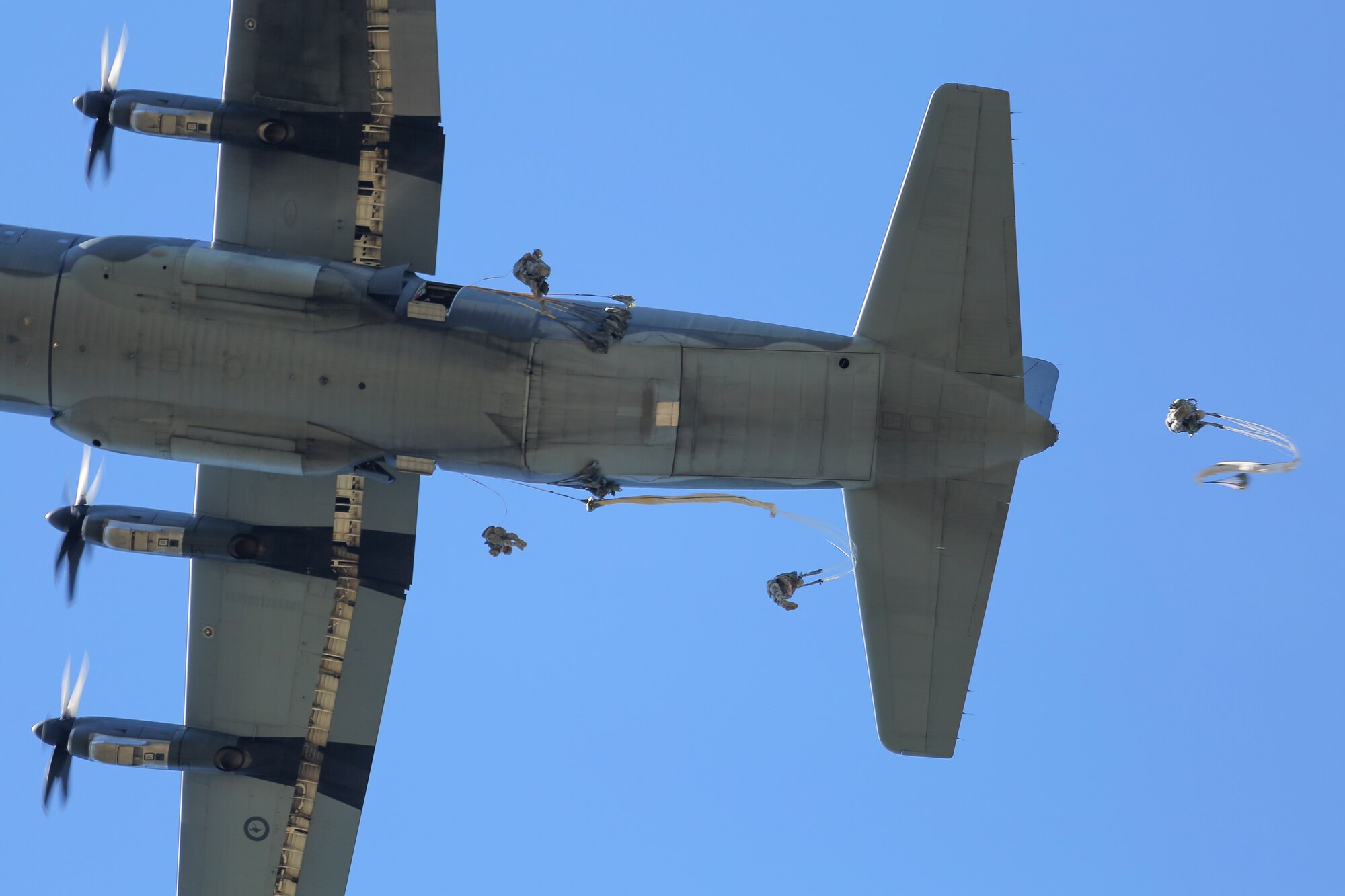 Paratroopers assigned to 1st Battalion (Airborne), 501st Infantry Regiment, 4th Infantry Brigade Combat Team (Airborne), 25th Infantry Division, U.S. Army Alaska jump out of a Royal Australian Air Force C-130J Super Hercules over Malemute drop zone, Joint Base Elmendorf-Richardson, Alaska, Aug. 24, 2015. Japanese Ground Self-Defense Force and U.S. Army paratroopers conducted the practice jump utilizing Royal Australian and U.S. Air Force aircraft as part of Pacific Airlift Rally 2015, a biennial, multilateral tactical military symposium designed to enhance military airlift interoperability and cooperation between nations of the Pacific region for future humanitarian missions. (U.S. Air Force photo by Alejandro Pena/Released)
