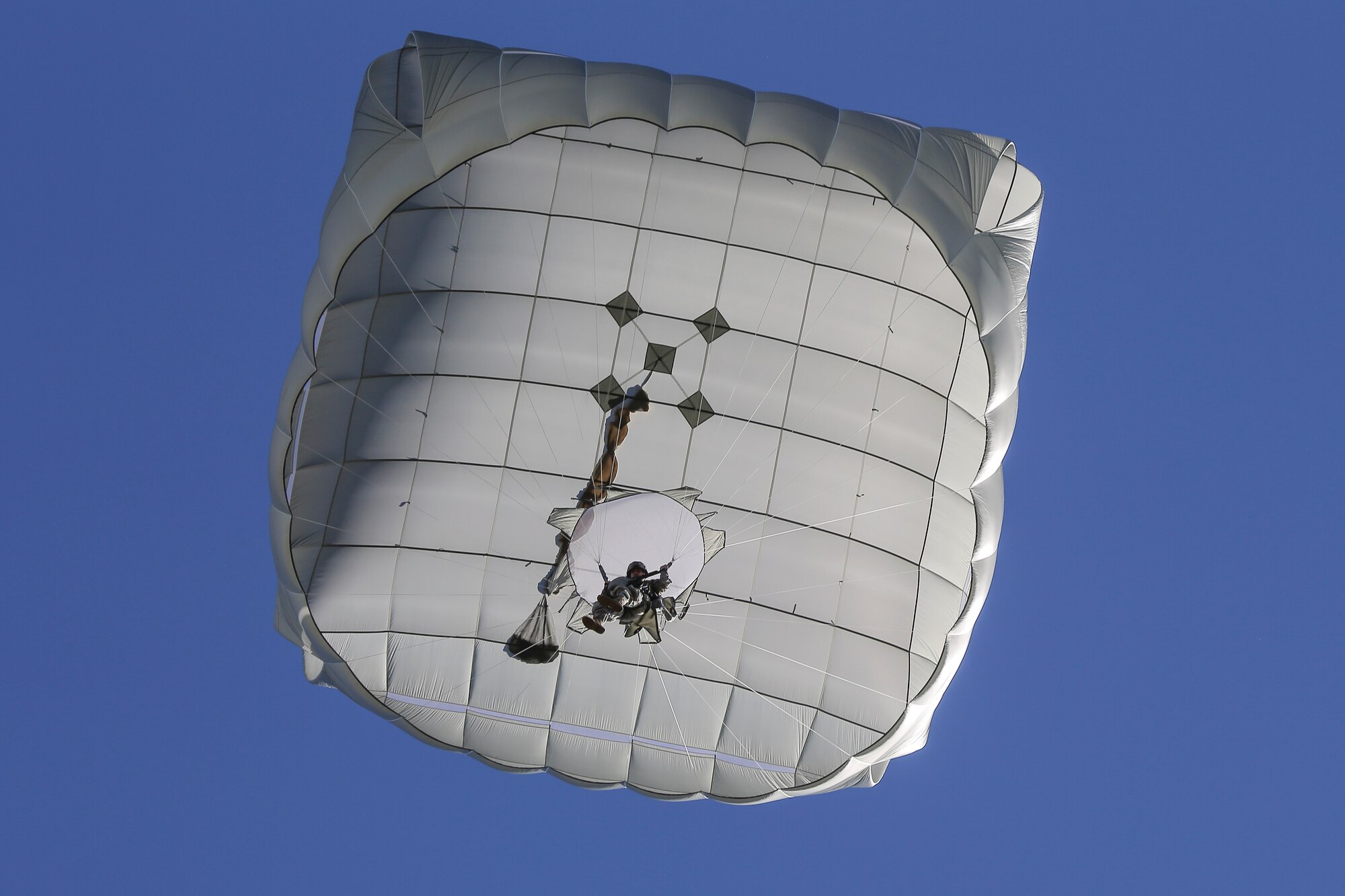 A paratrooper assigned to 1st Battalion (Airborne), 501st Infantry Regiment, 4th Infantry Brigade Combat Team (Airborne), 25th Infantry Division, U.S. Army Alaska, descends during a practice jump over Malemute drop zone, Joint Base Elmendorf-Richardson, Alaska, Aug. 24, 2015. Japanese Ground Self-Defense Force and U.S. Army paratroopers conducted the practice jump utilizing Royal Australian and U.S. Air Force aircraft as part of Pacific Airlift Rally 2015, a biennial, multilateral tactical military symposium designed to enhance military airlift interoperability and cooperation between nations of the Pacific region for future humanitarian missions. (U.S. Air Force photo by Alejandro Pena/Released)
