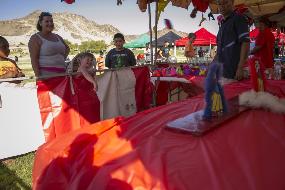 Kylie Scott, 5, daughter of Cpl. Joseph Scott, range maintenance man, 3rd Light Armored Reconnaissance Battalion, participates in carnival games during Lincoln Military Housing’s ‘Back to School’ carnival at Lincoln Sports Field, Aug. 21, 2015. LMH and Marine volunteers also served free funnel cake, pretzels, hamburgers, hot dogs, soda, and water. (Official Marine Corps photo by Pfc. Levi Schultz/Released)
