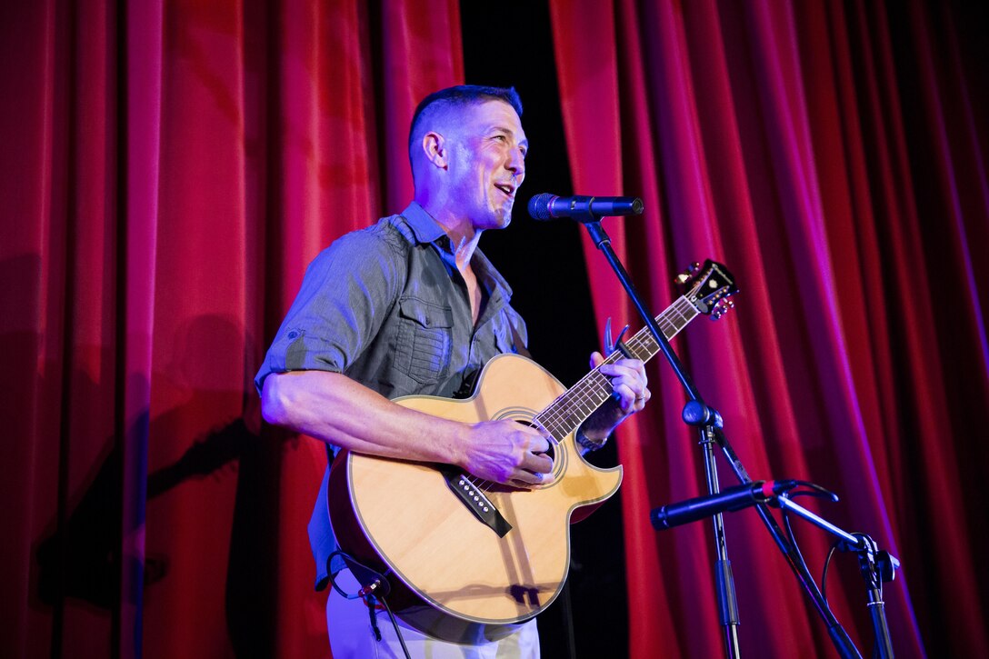 Gunnery Sgt. Jonathon D. Ginn, field artillery operations staff non-commissioned officer, Marine Corps Tactics and Operations Group, performs during the Single Marine Program’s annual ‘Marines got talent’ show at the Sunset Cinema aboard the Combat Center, Aug. 21, 2015. (Official Marine Corps photo by Lance Cpl. Connor Hancock/Released)