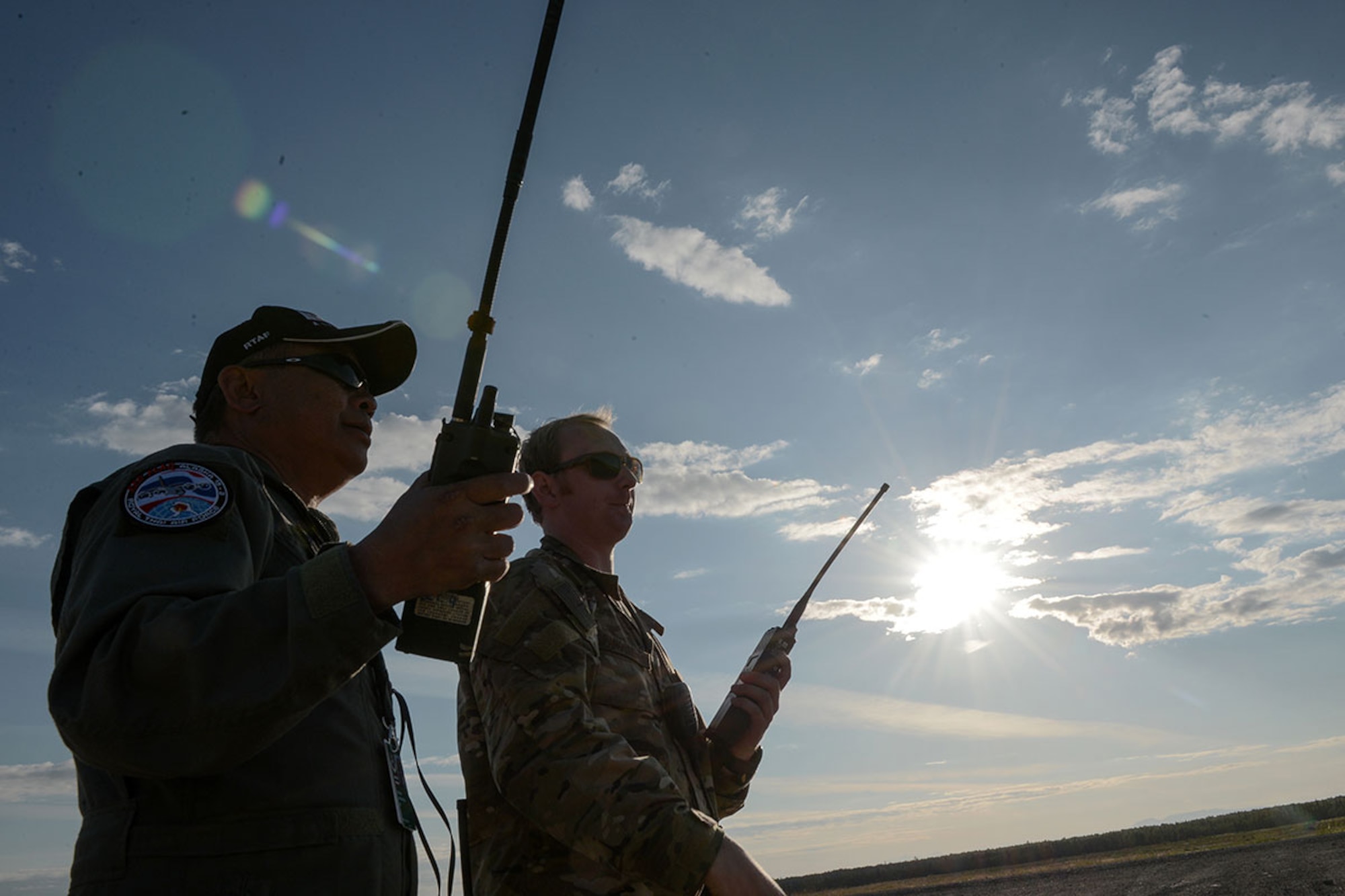 Flight Sgt. 1st Class Saknarong Wongin, Royal Thai Air Force combat controller, and U.S. Air Force Capt. Michael Spanogle, 3rd Air Support Operations Squadron Air Mobility Liaison Officer, coordinate an airdrop during Red Flag Alaska 15-3. (U.S. Air Force photo/Staff Sgt. Cody Ramirez)